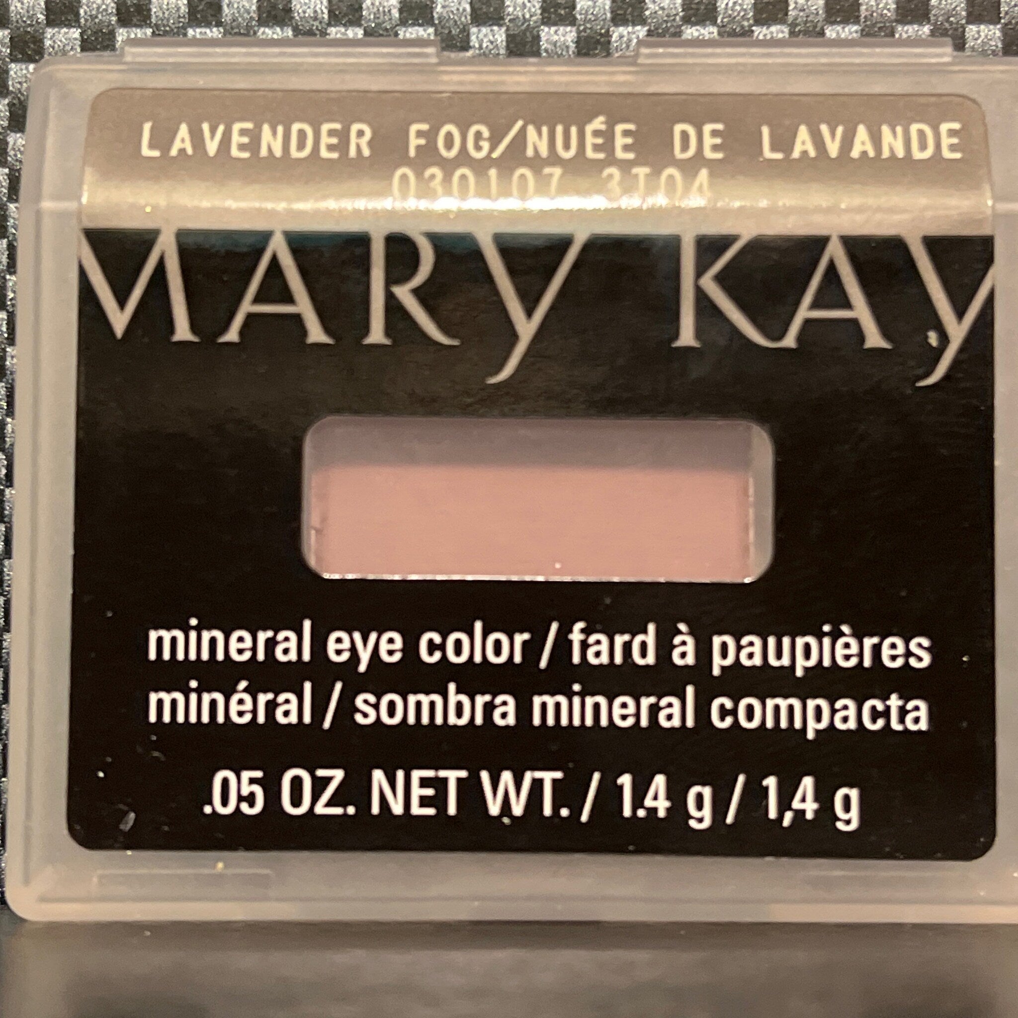 Side view of matte lavender mineral eye shadow pot showing smooth powder texture and compact size