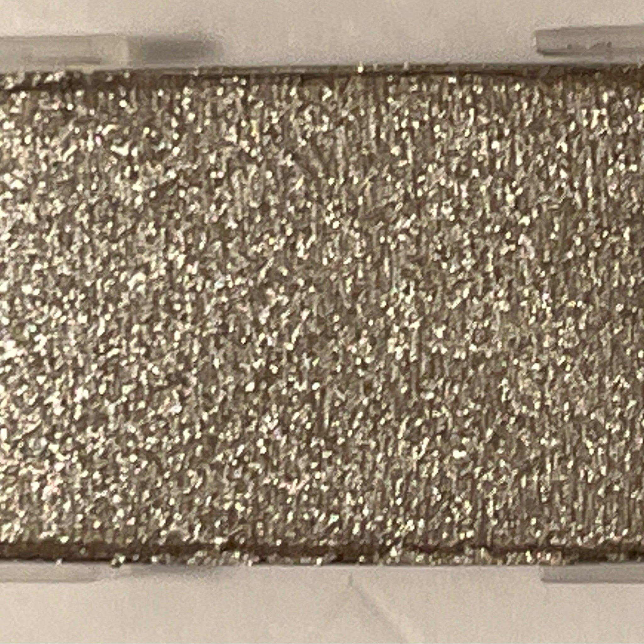 Close-up of shimmering mineral eye shadow in polished stone hue with metallic finish