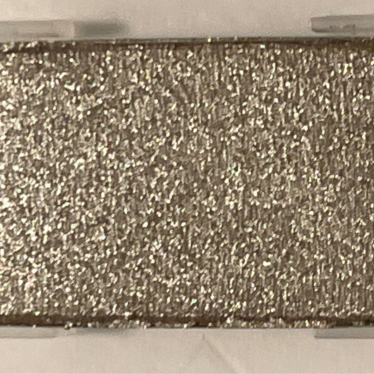 Close-up of shimmering mineral eye shadow in polished stone hue with metallic finish