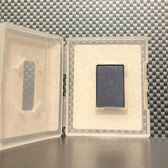 Hand applying shimmering navy blue mineral eye shadow with a fluffy brush for a smoky eye look