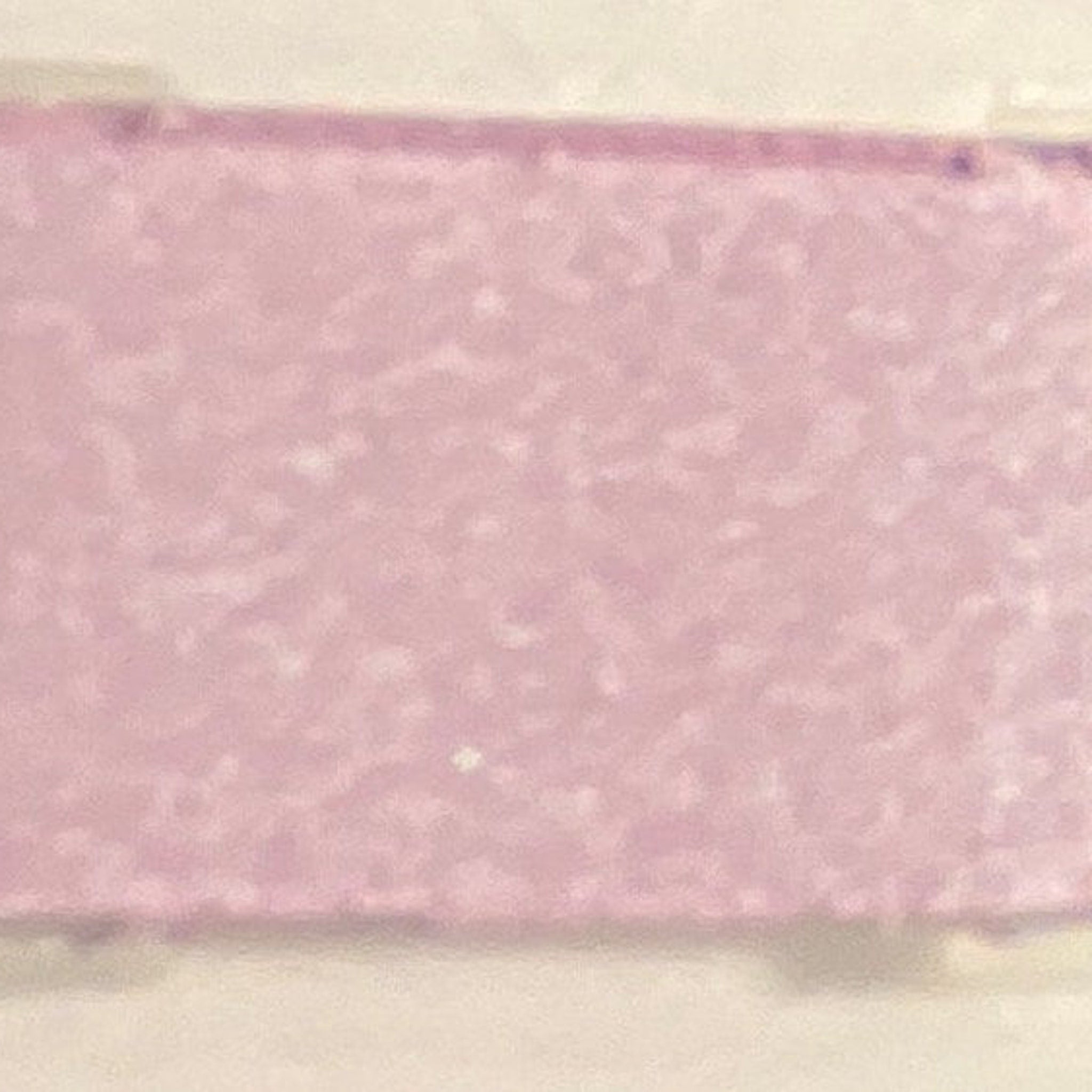 Close-up of shimmering dusty lilac mineral eye shadow in compact with reflective surface