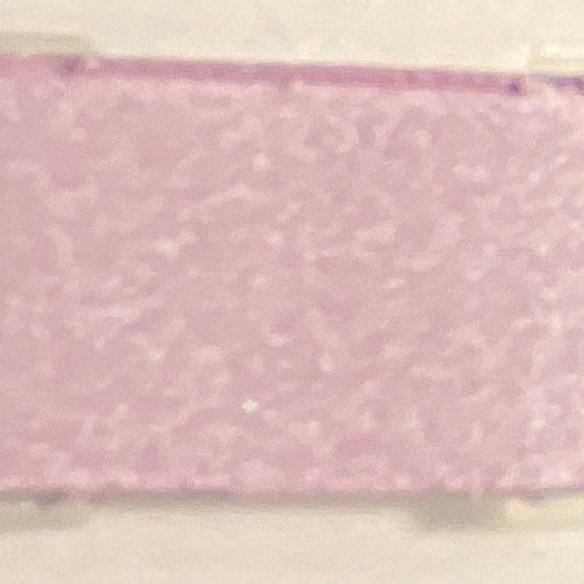 Close-up of shimmering dusty lilac mineral eye shadow in compact with reflective surface