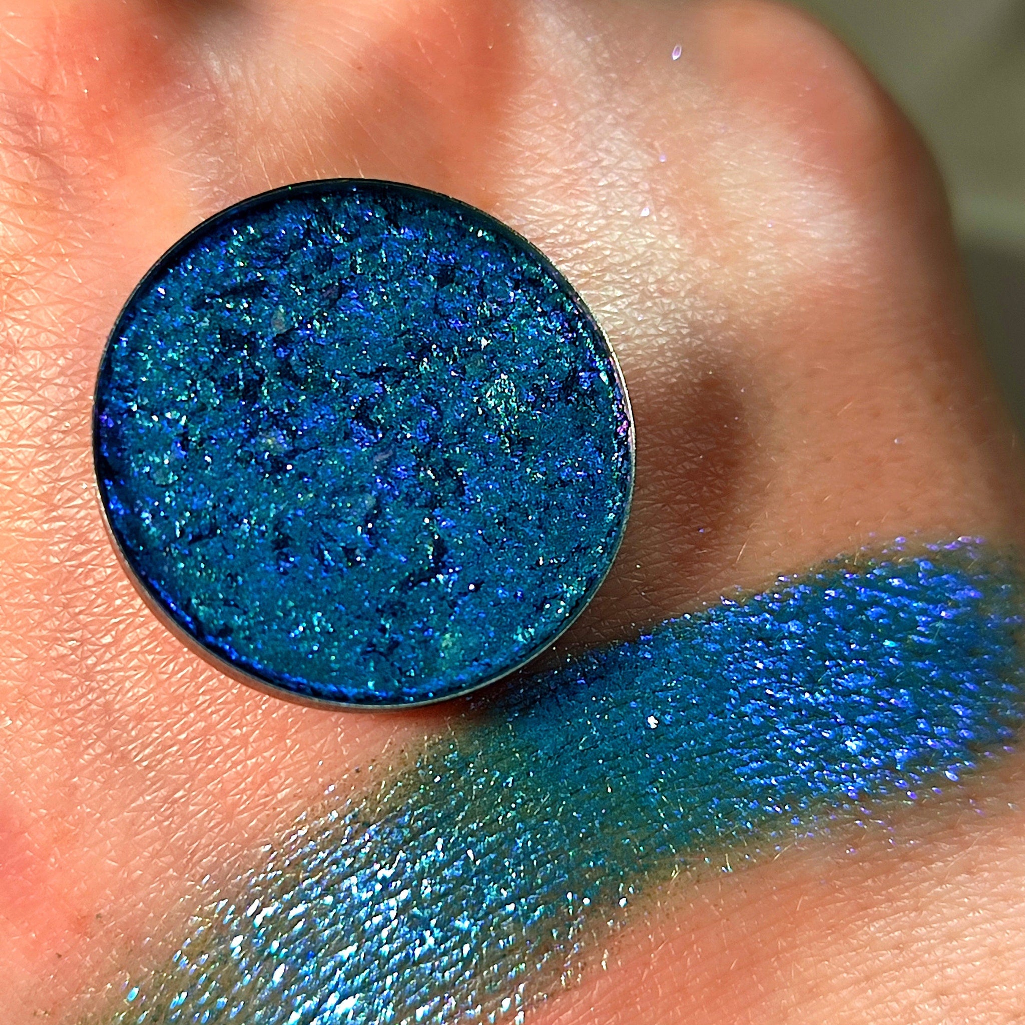Eye shadow, teal blue shimmer, compact and swatch on skin