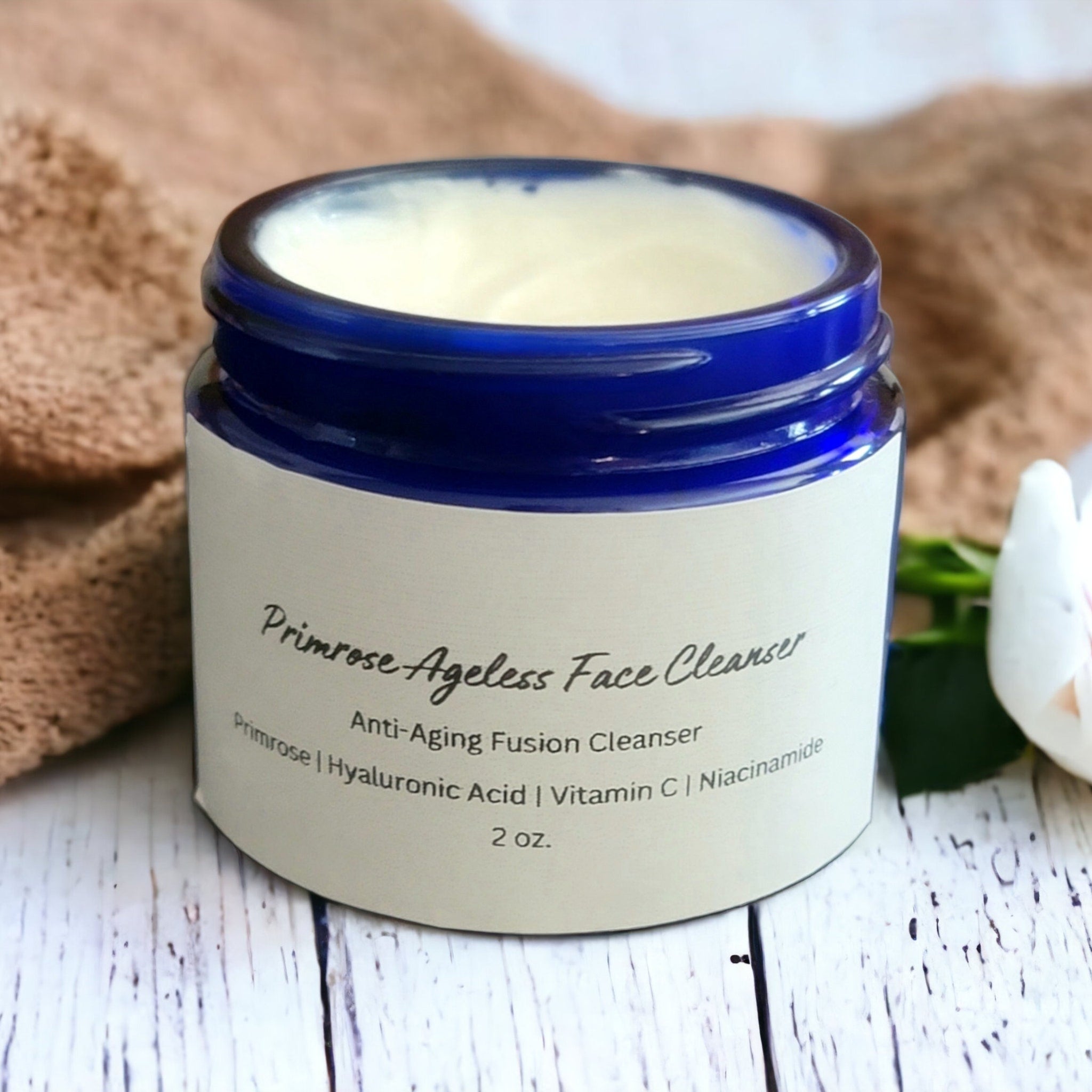 Face cleanser jar with blue rim, white label, and cream contents, Primrose Ageless Face Cleanser text visible
