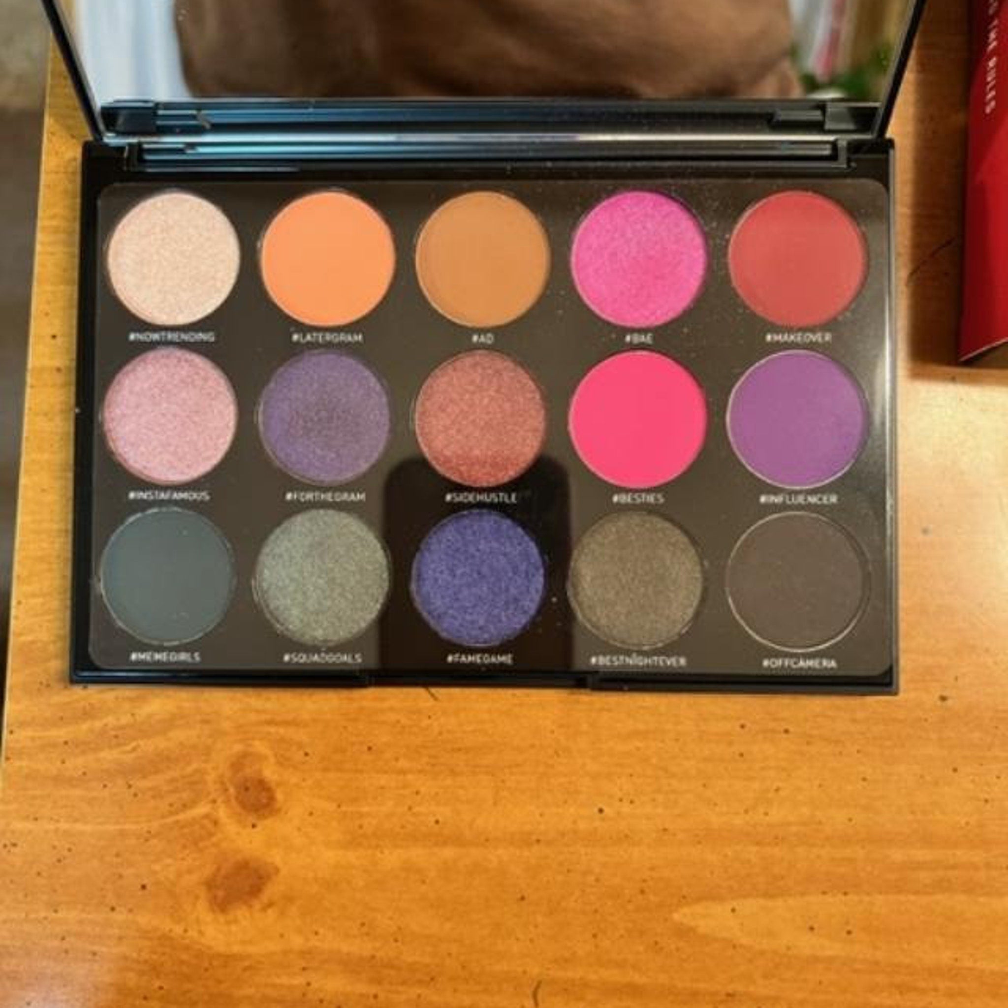 Side view of Morphe Social Butterfly palette showing 15 vibrant powder shadows in warm neutrals and bold jewel tones