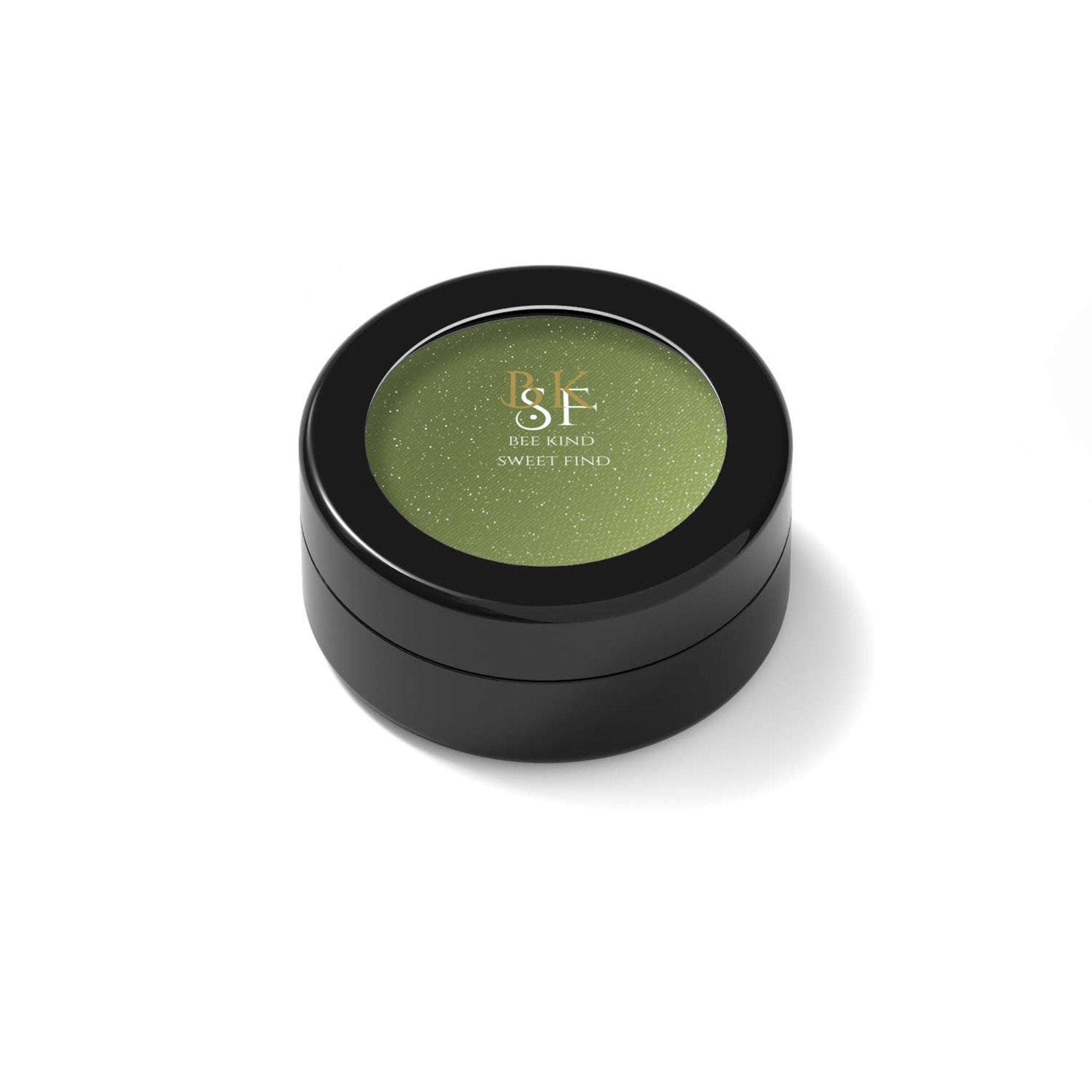 Eye shadow compact with green shimmer, black container, and brand text