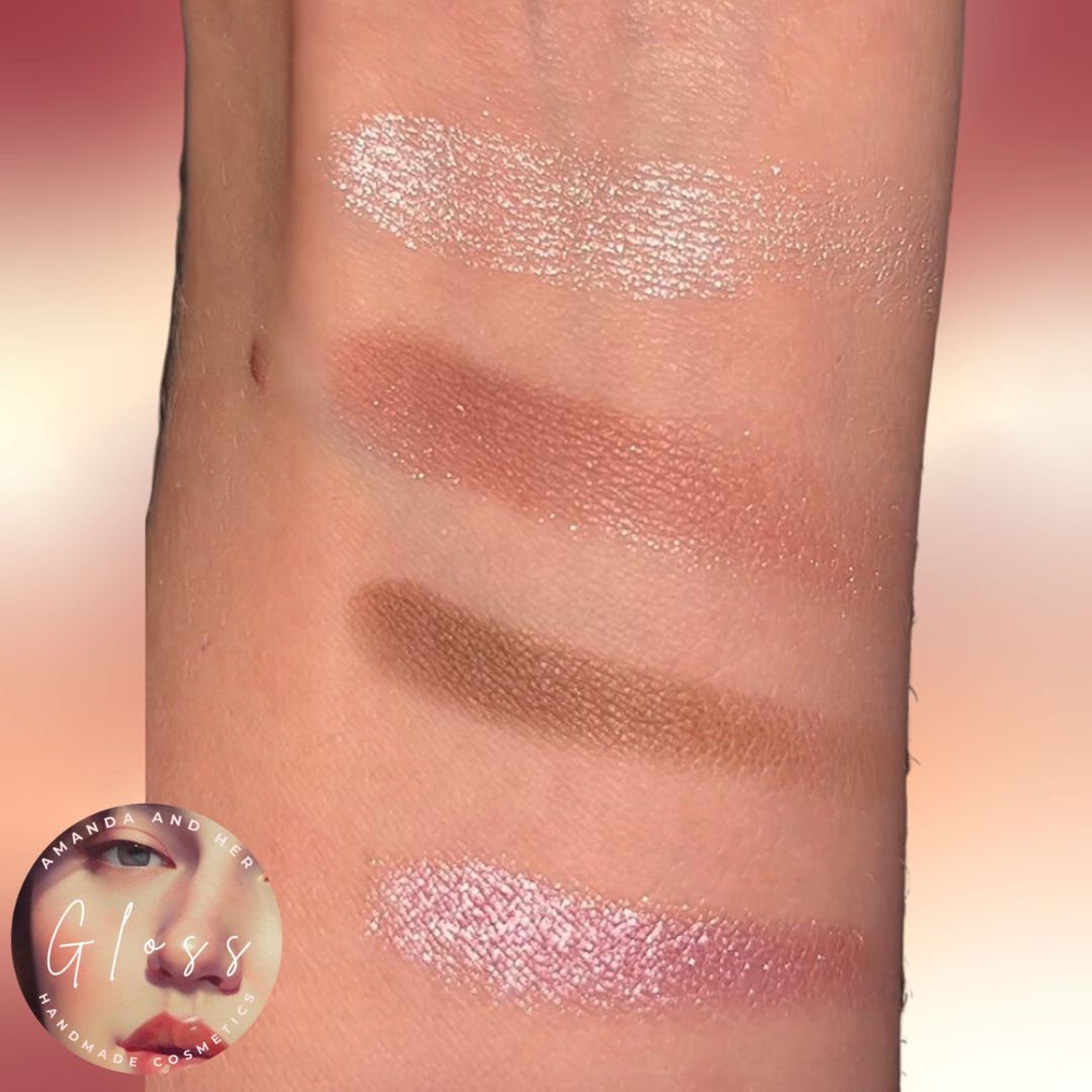 Eyeshadow swatches with various colors and textures on skin, Amanda and Her Gloss brand visible