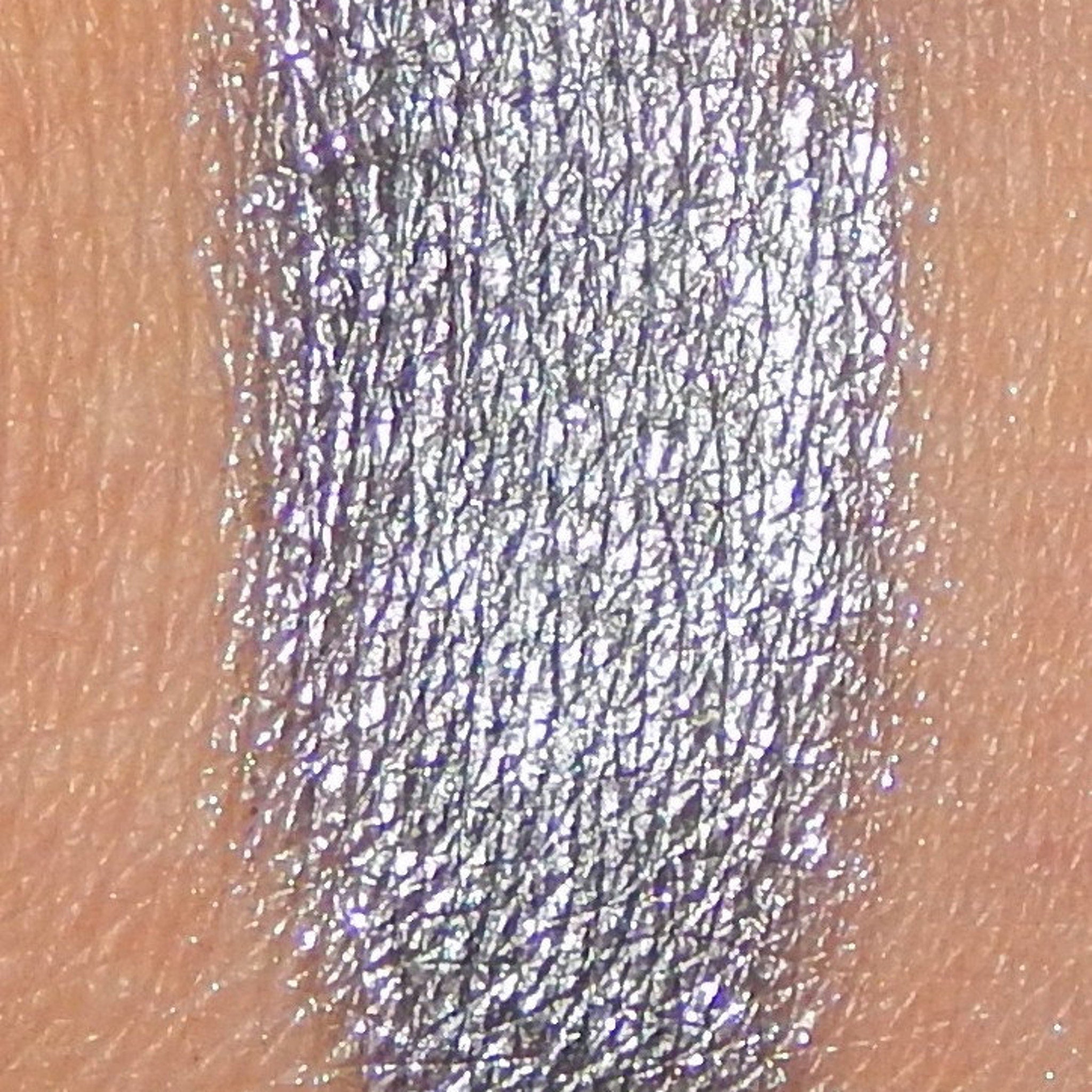 Side view of Arc Angel Mineral Eye Shadow pot showcasing its iridescent blue-purple pigment and compact round case