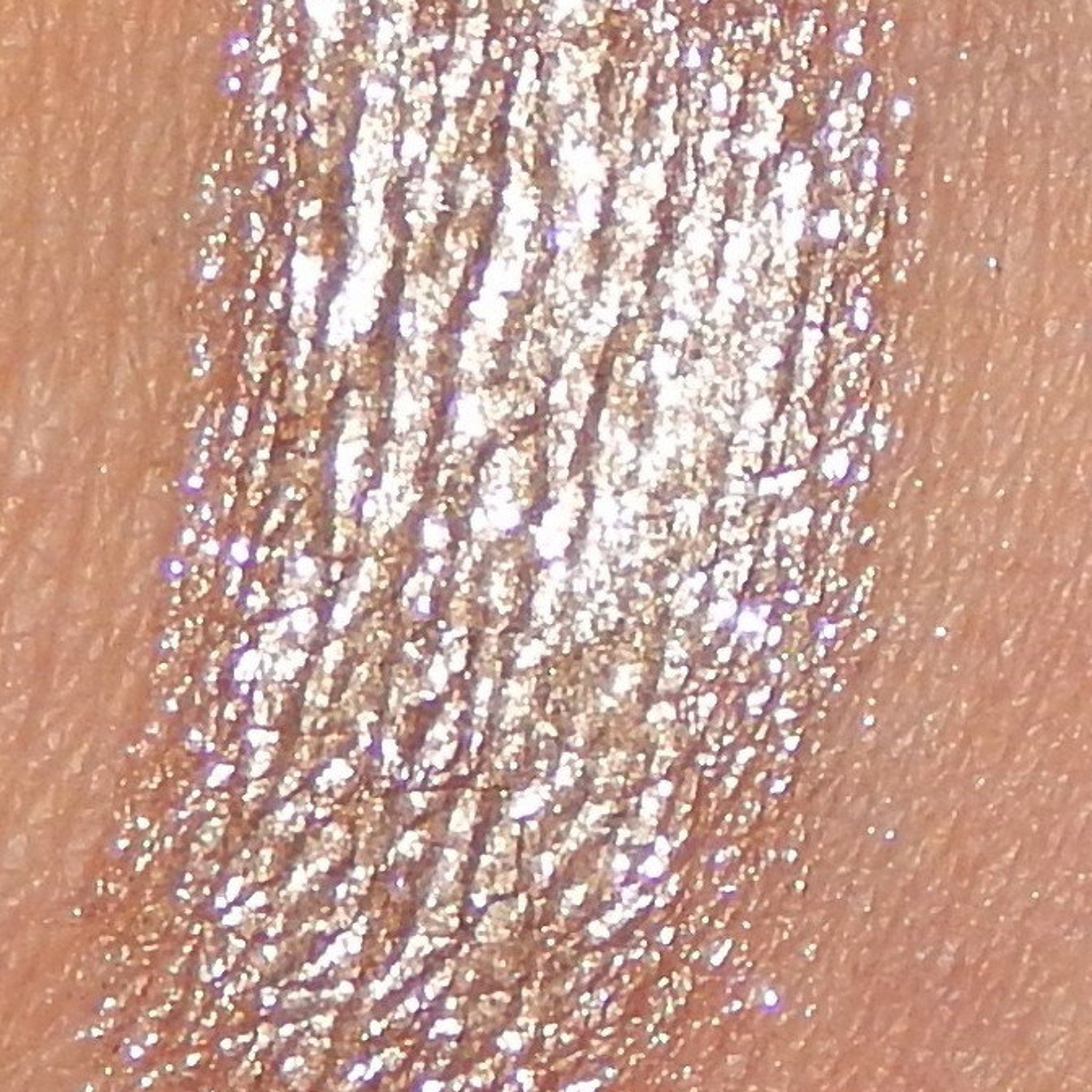Side view of frothy mineral eyeshadow pot showing soft pink powder texture and compact size