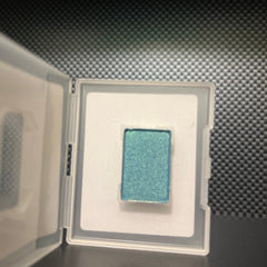 Side view of mineral eye shadow in azure blue with smooth satin finish and compact case