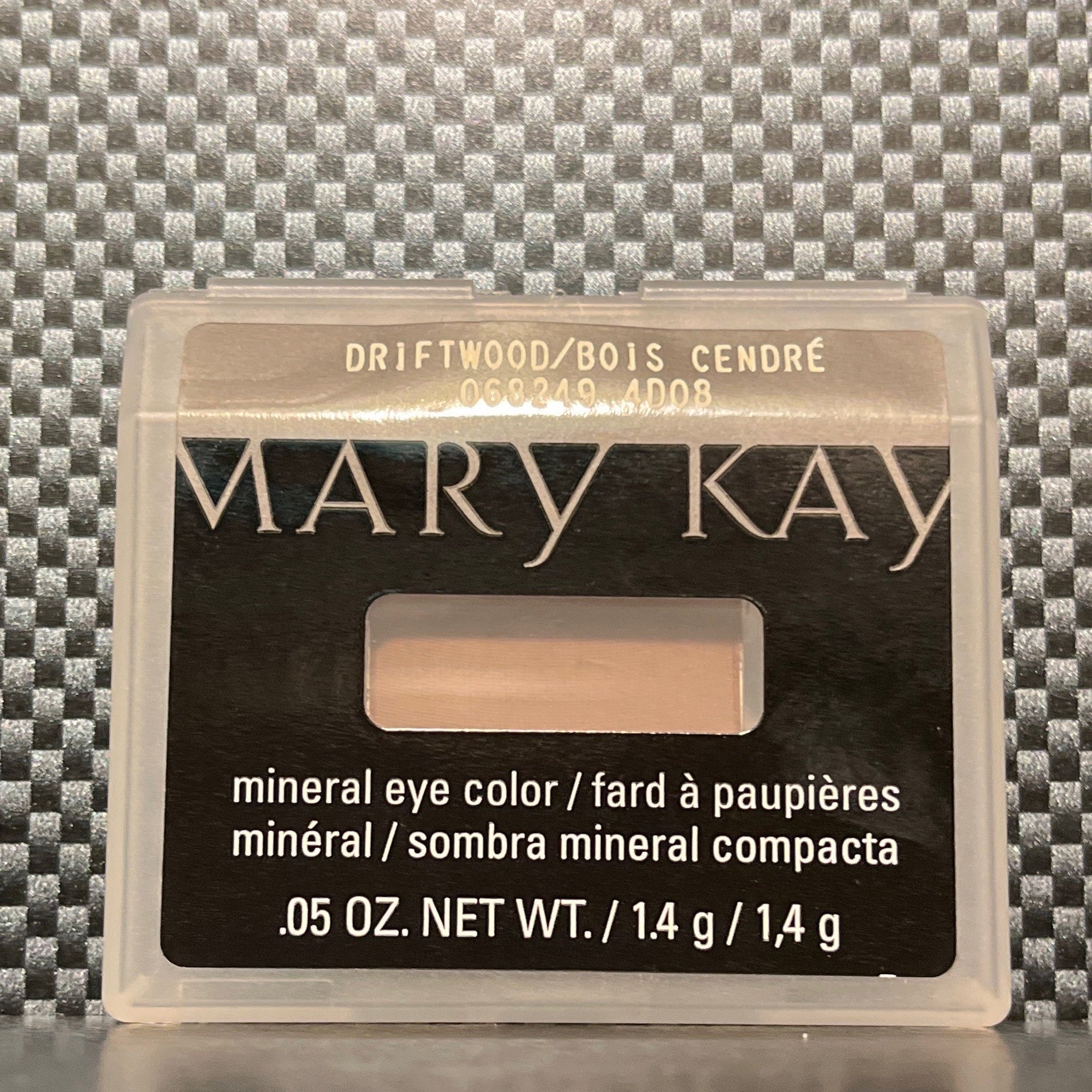 Side view of matte driftwood eyeshadow pan showing neutral taupe-brown powder texture