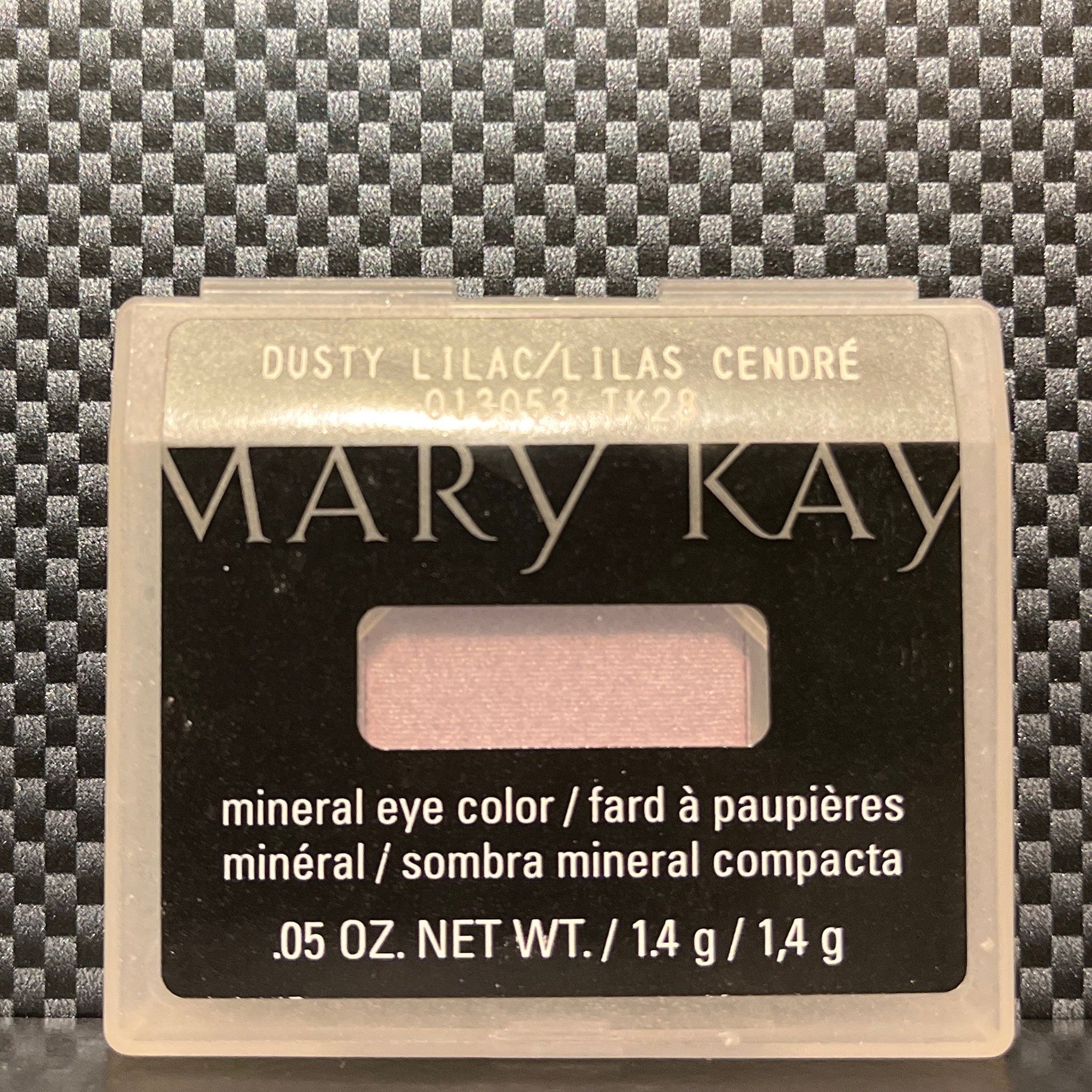 Side view of shimmering dusty lilac mineral eye shadow in compact, showcasing its iridescent finish and fine powder texture