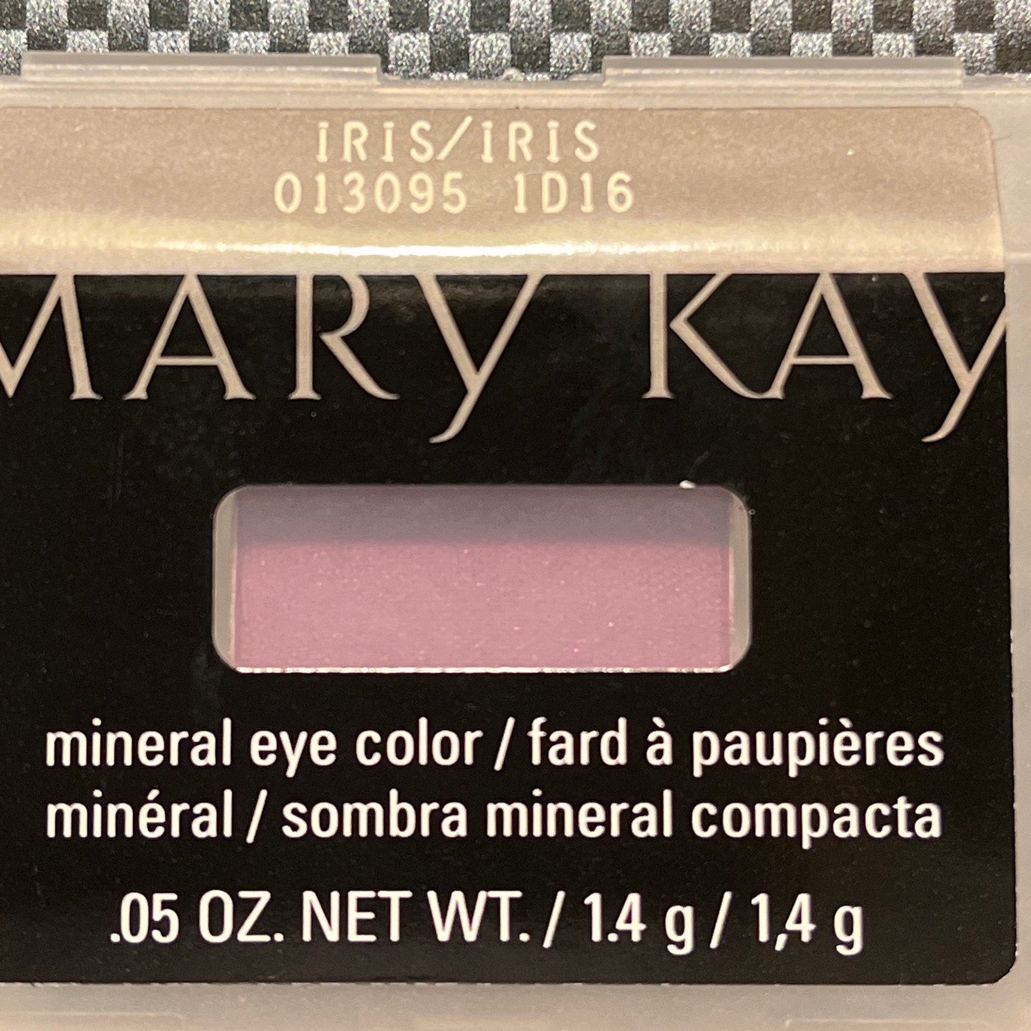 Side view of Shimmering Iris mineral eye shadow pot showing iridescent purple powder texture