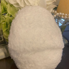 White fluffy material, egg-shaped object, soft texture, decorative setting