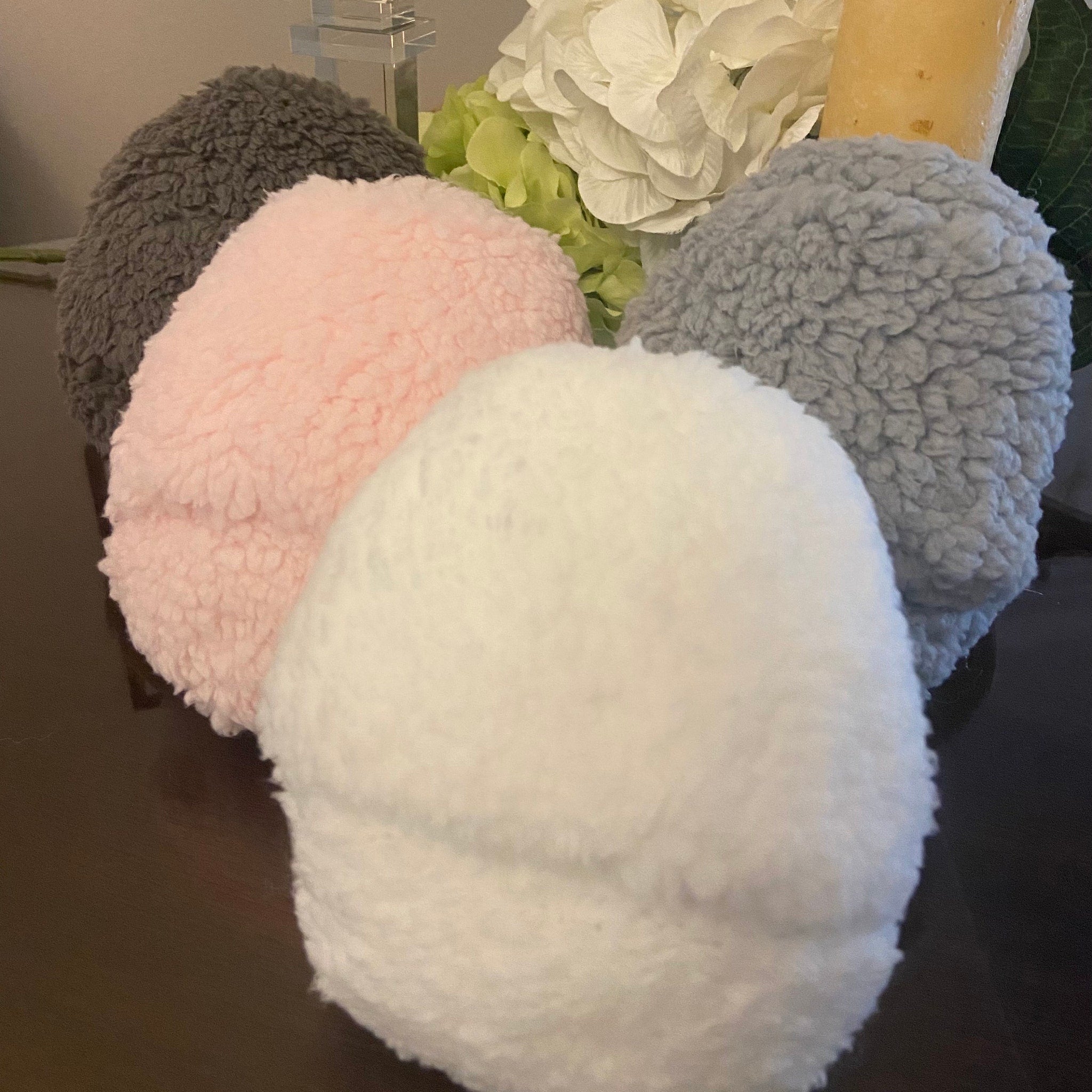 Fuzzy balls in gray, pink, and white with a fluffy texture, arranged together.