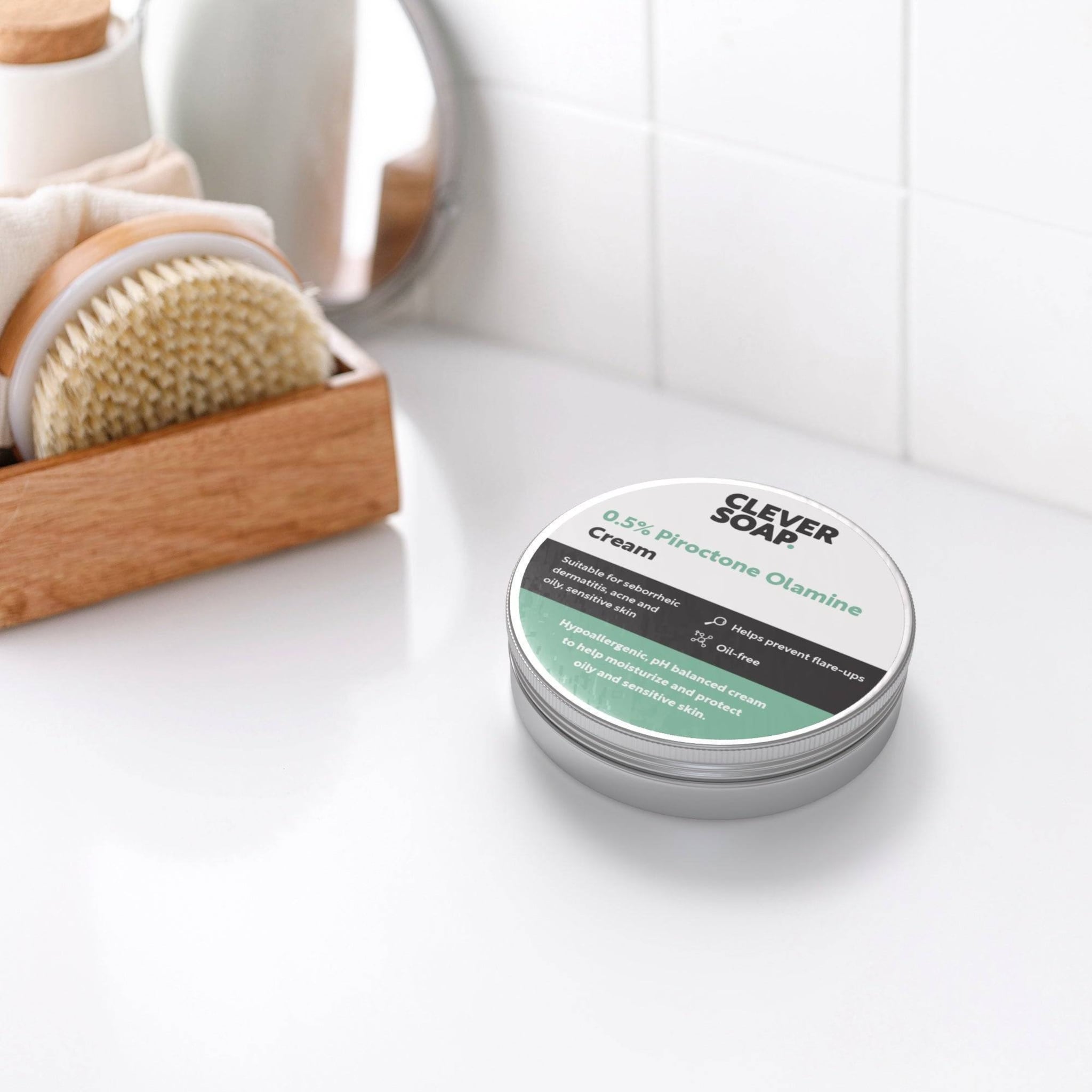 Cream jar with Clever Soap branding, silver metal container, and green and white label on a white surface