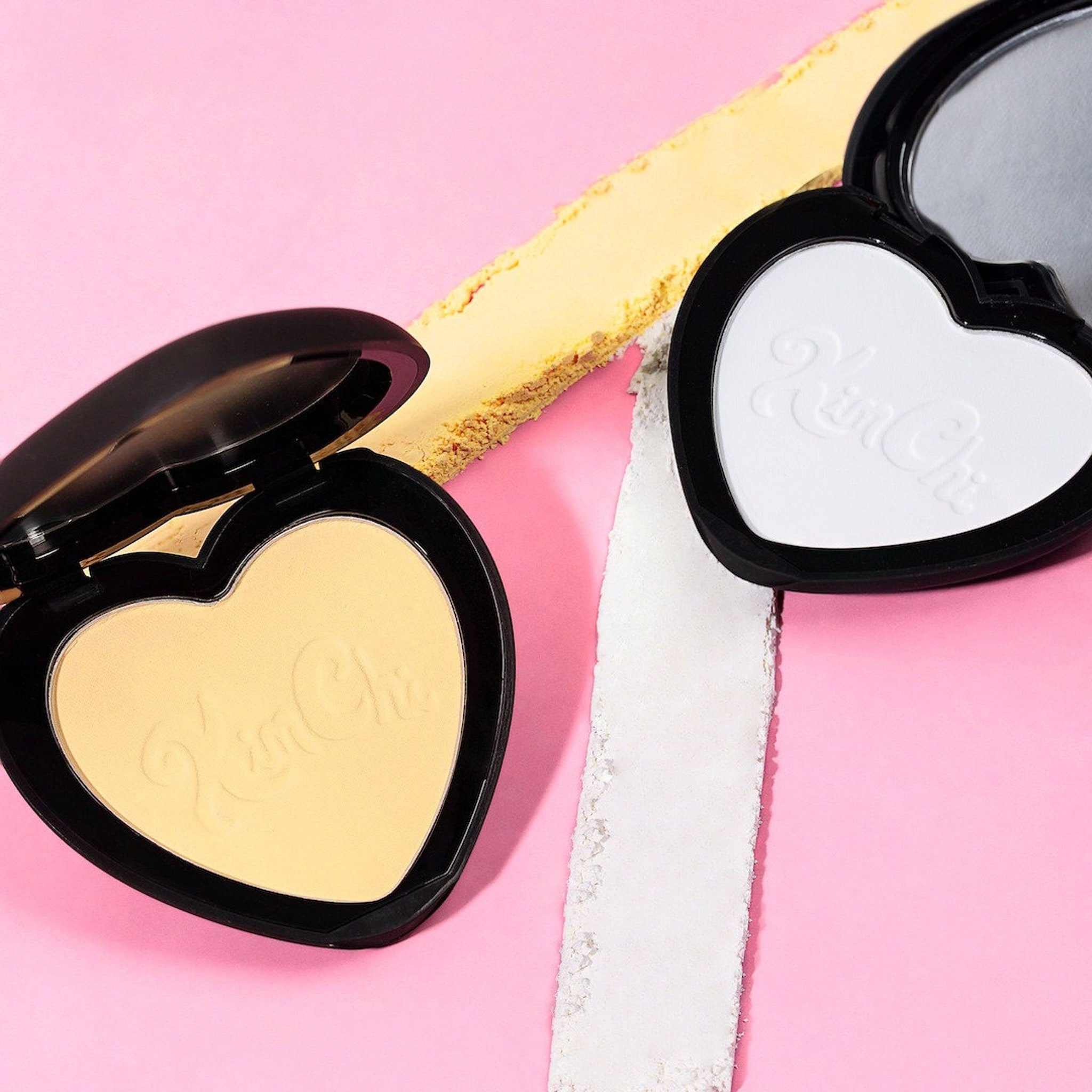 Heart-shaped compact powder with black case, yellow and white powder, Kim Chi brand text