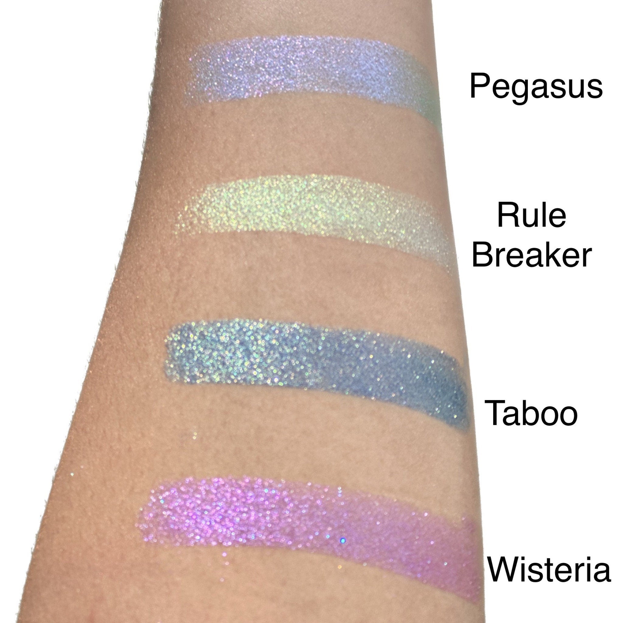 Close-up of fingertips applying duo chrome eyeshadow with shimmering color shift effect on eyelid