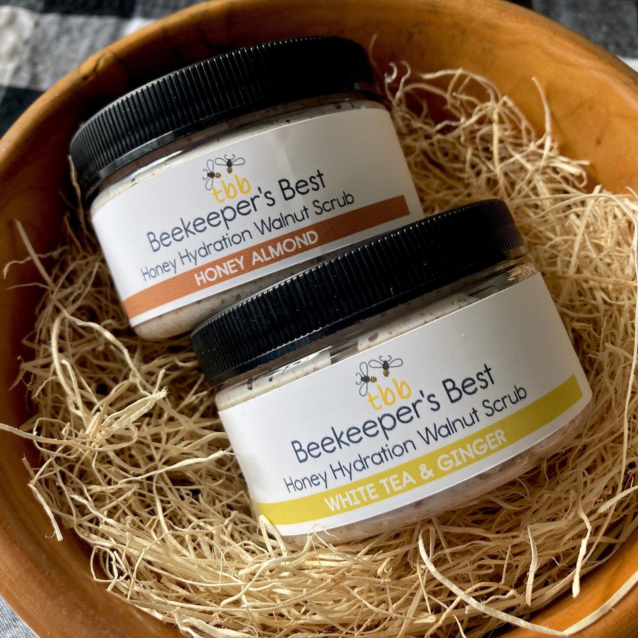 Honey Hydration Walnut Scrub jars with black lids, white labels, and "Beekeeper's Best" text in wooden bowl