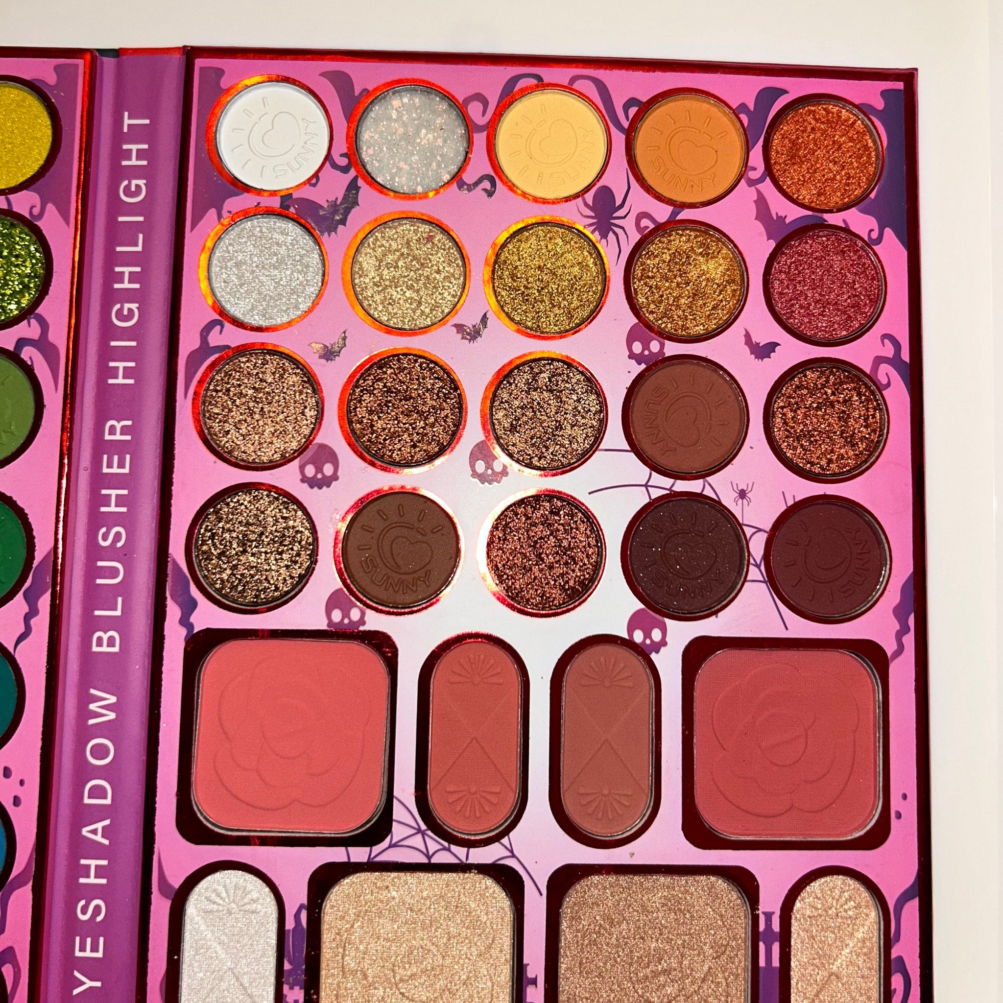 Halloween eye shadow palette showcasing bonus glitter shades in orange, black, and purple with detailed embossed designs