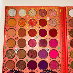 Side view of Halloween eye shadow palette showcasing vibrant orange, black, and purple matte shades in rectangular pans