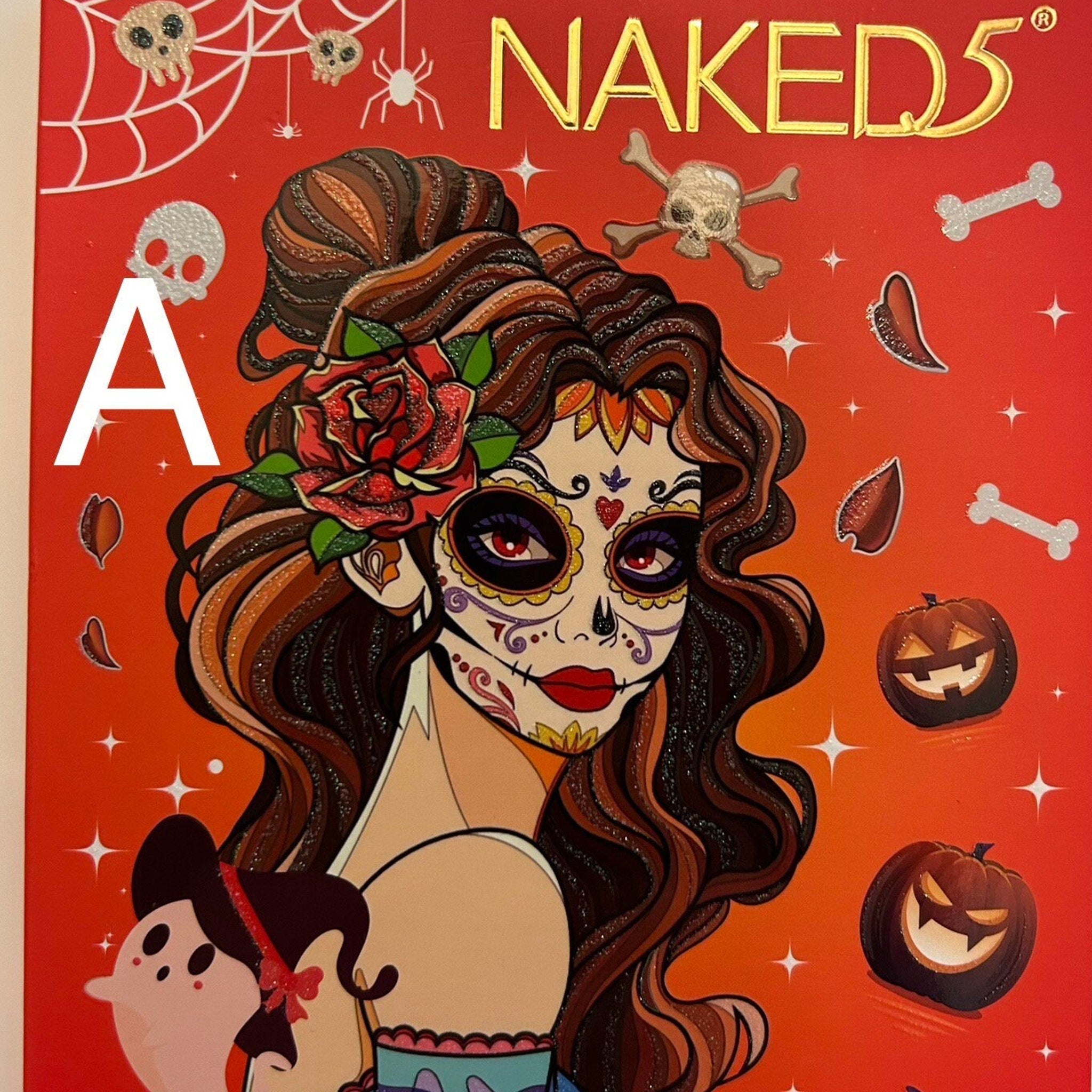 Halloween eye shadow palette with vibrant orange, black, and purple shades in a sleek black compact.