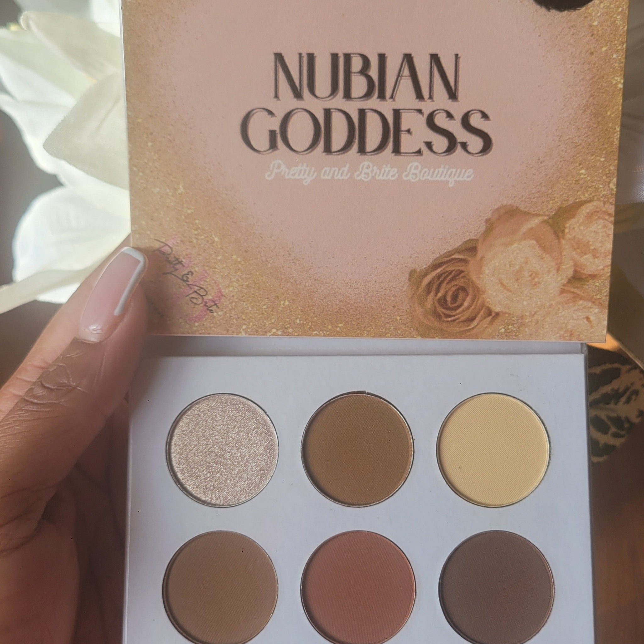 Open Nubian Goddess Eyeshadow Palette displaying 12 vibrant matte and shimmer shades in warm earthy tones