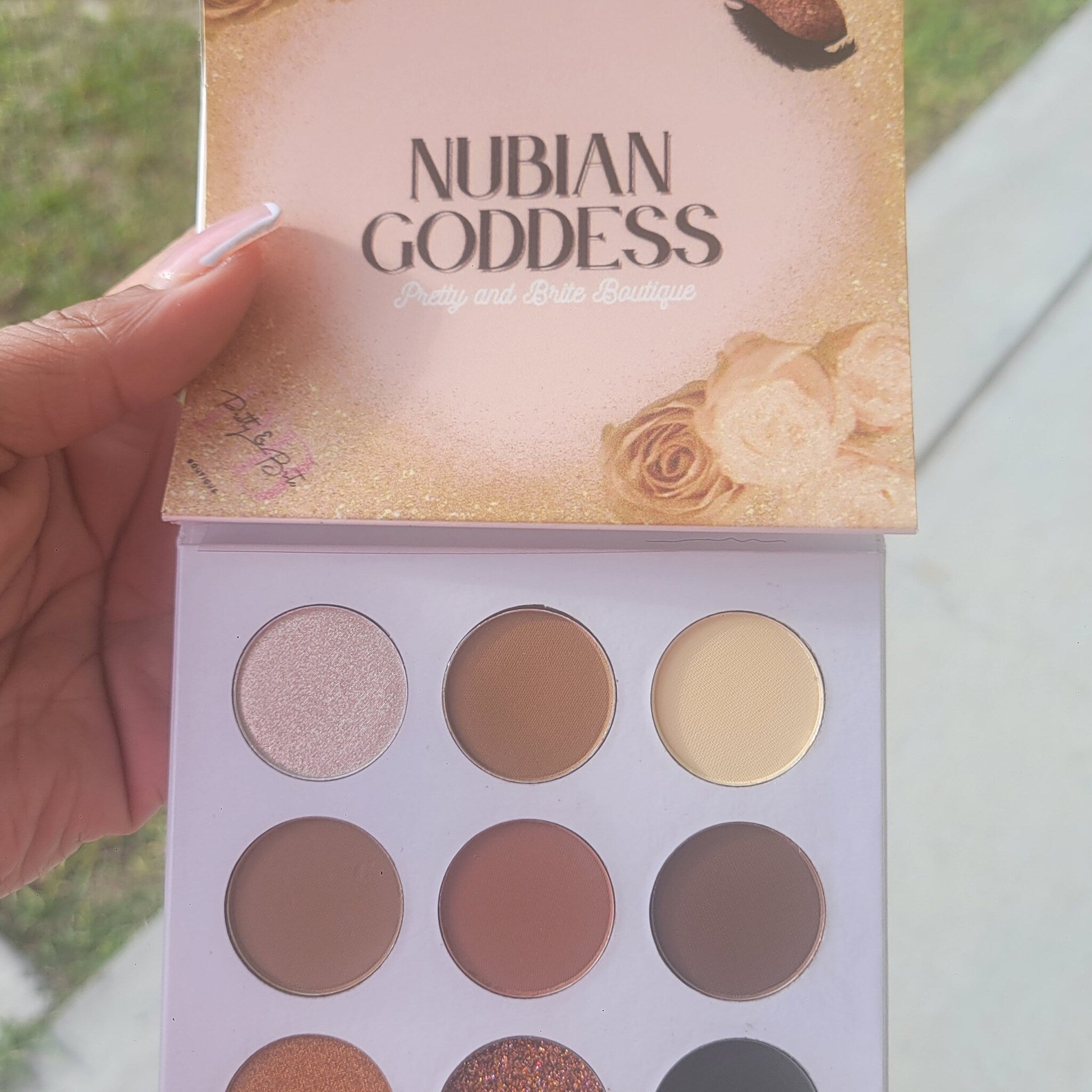 Close-up of Nubian Goddess Eyeshadow Palette showing rich matte and shimmer shades in warm browns and golds