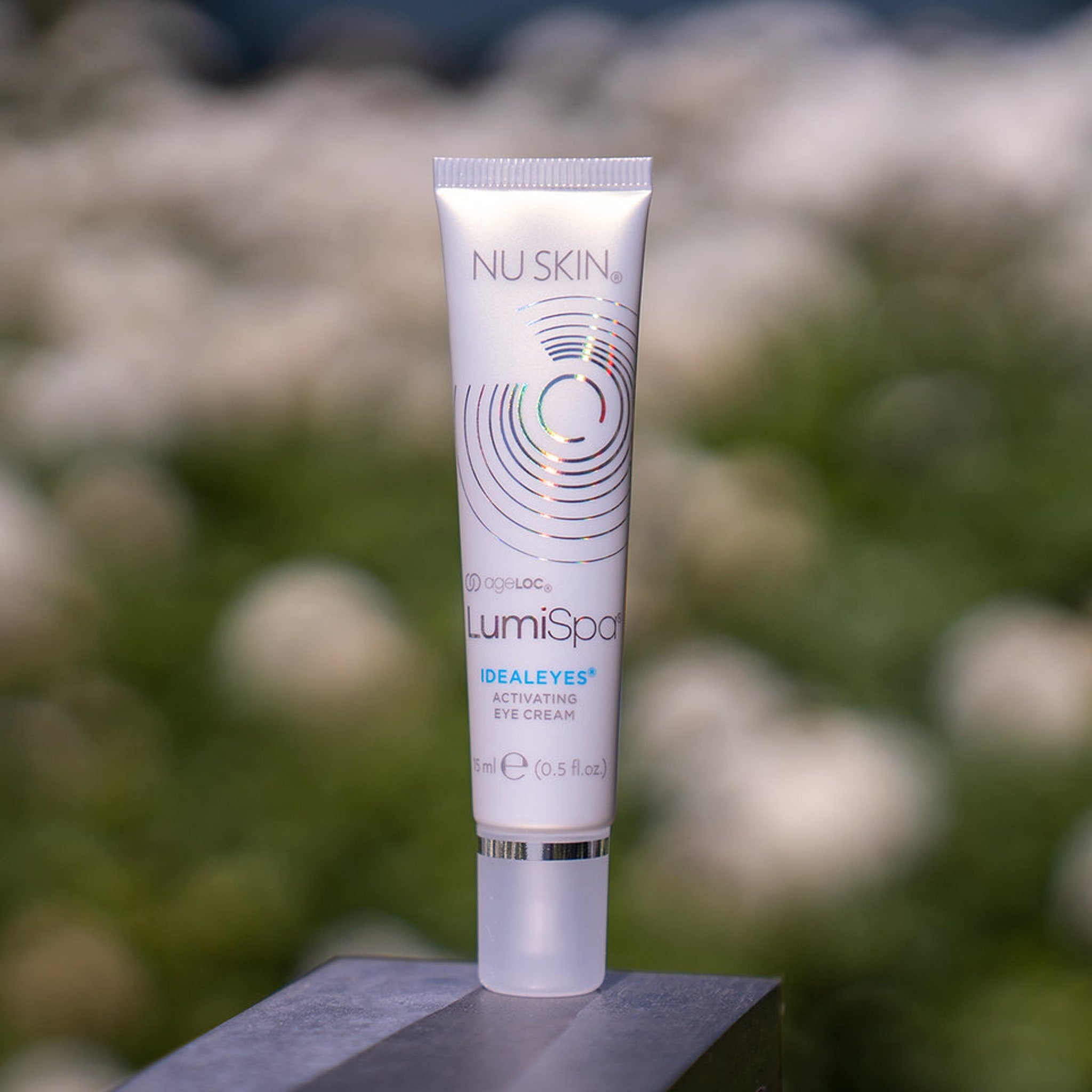 Eye makeup activating cream, white tube, silver cap, Nu Skin LumiSpa IdealEyes brand name visible