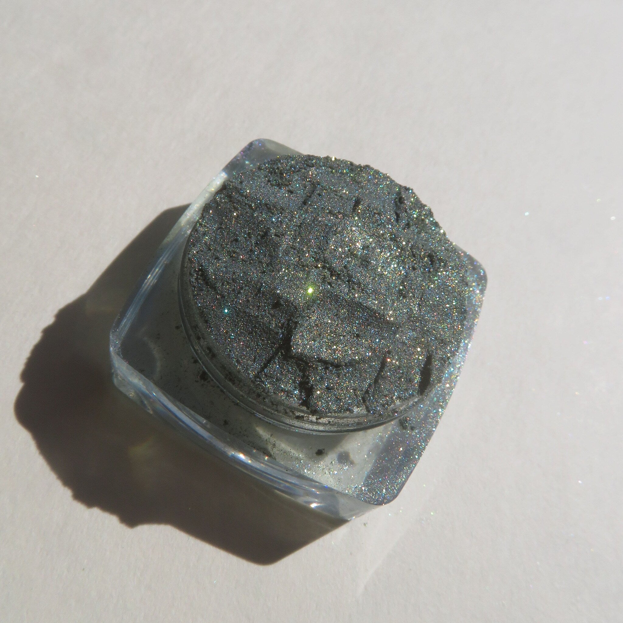 Glitter eyeshadow powder, dark gray, sparkly, in clear square container