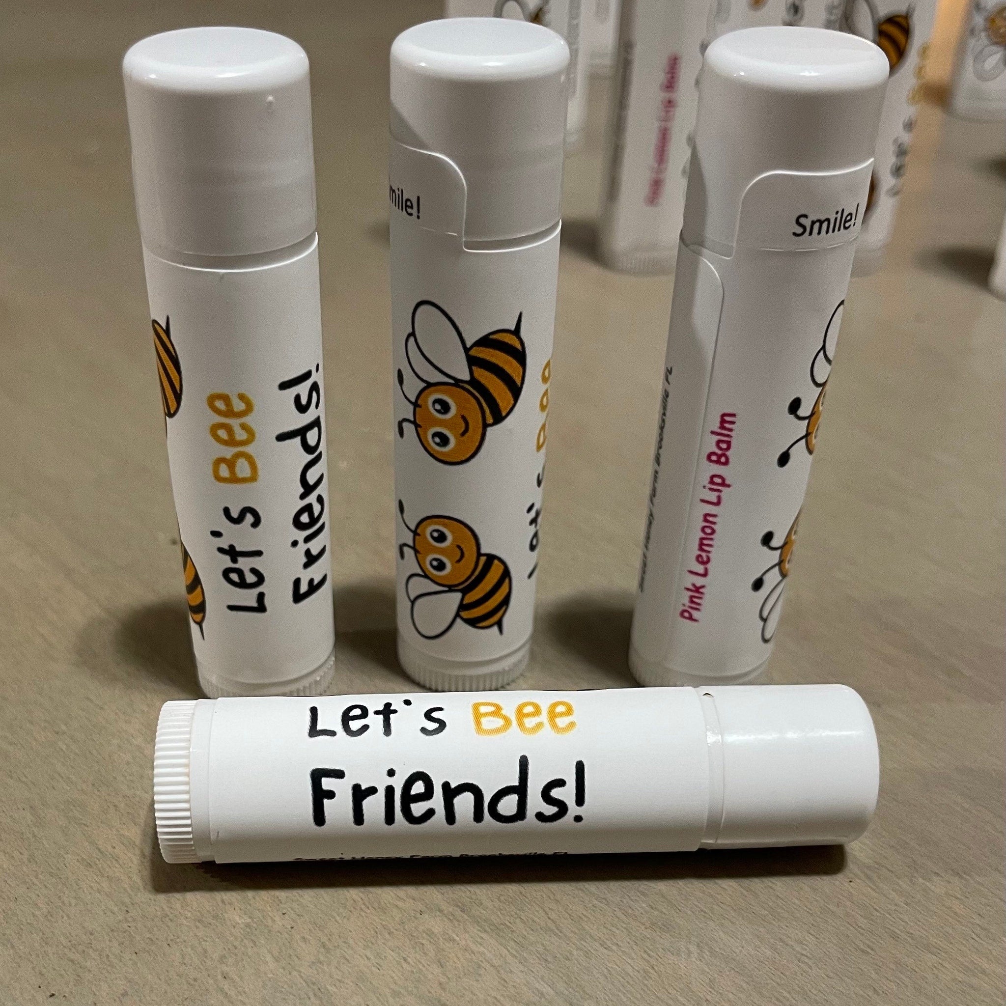 Lip balm tubes with white and bee design, "Let's Bee Friends!" text, Sweet Honey Farm brand