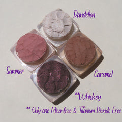 Four vegan mineral eyeshadows in matte and shimmer finishes displayed in round pots with sifter lids.