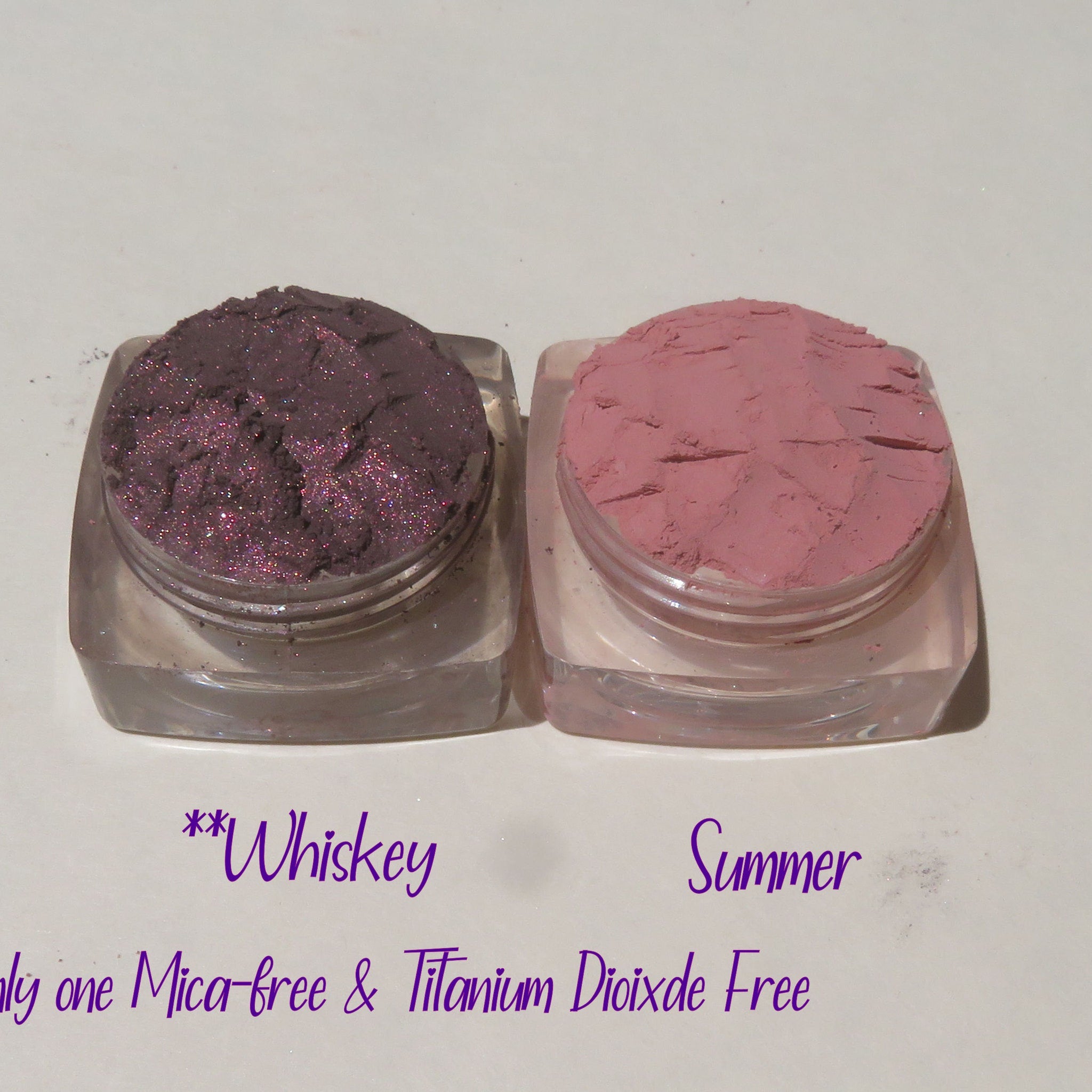 Hand applying shimmery taupe loose mineral eyeshadow with a fluffy brush for a soft blended look