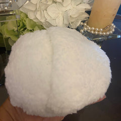 White fluffy material, round shape, held in hand