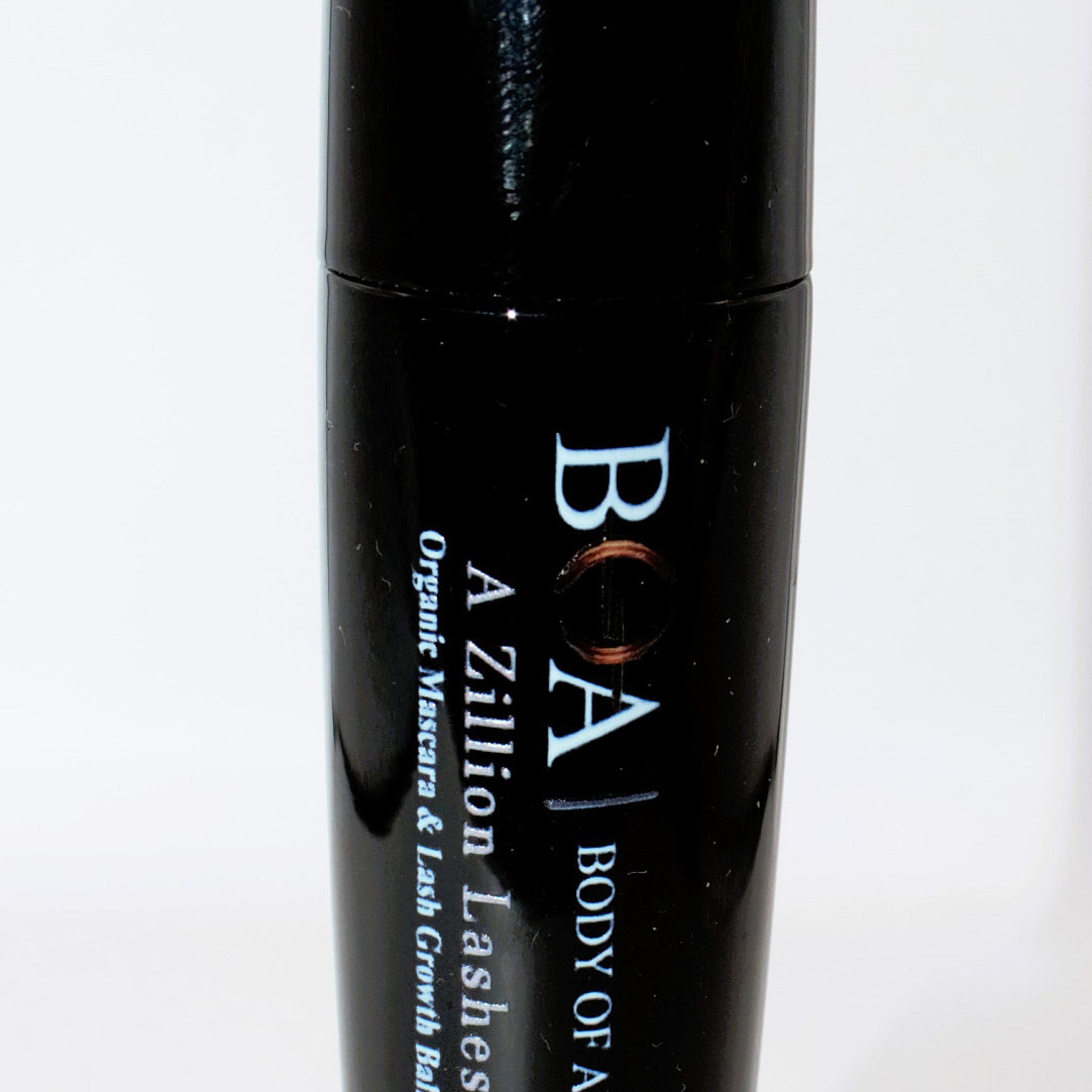 Mascara tube, black glossy finish, white text "BOA A Zillion Lashes" on tube