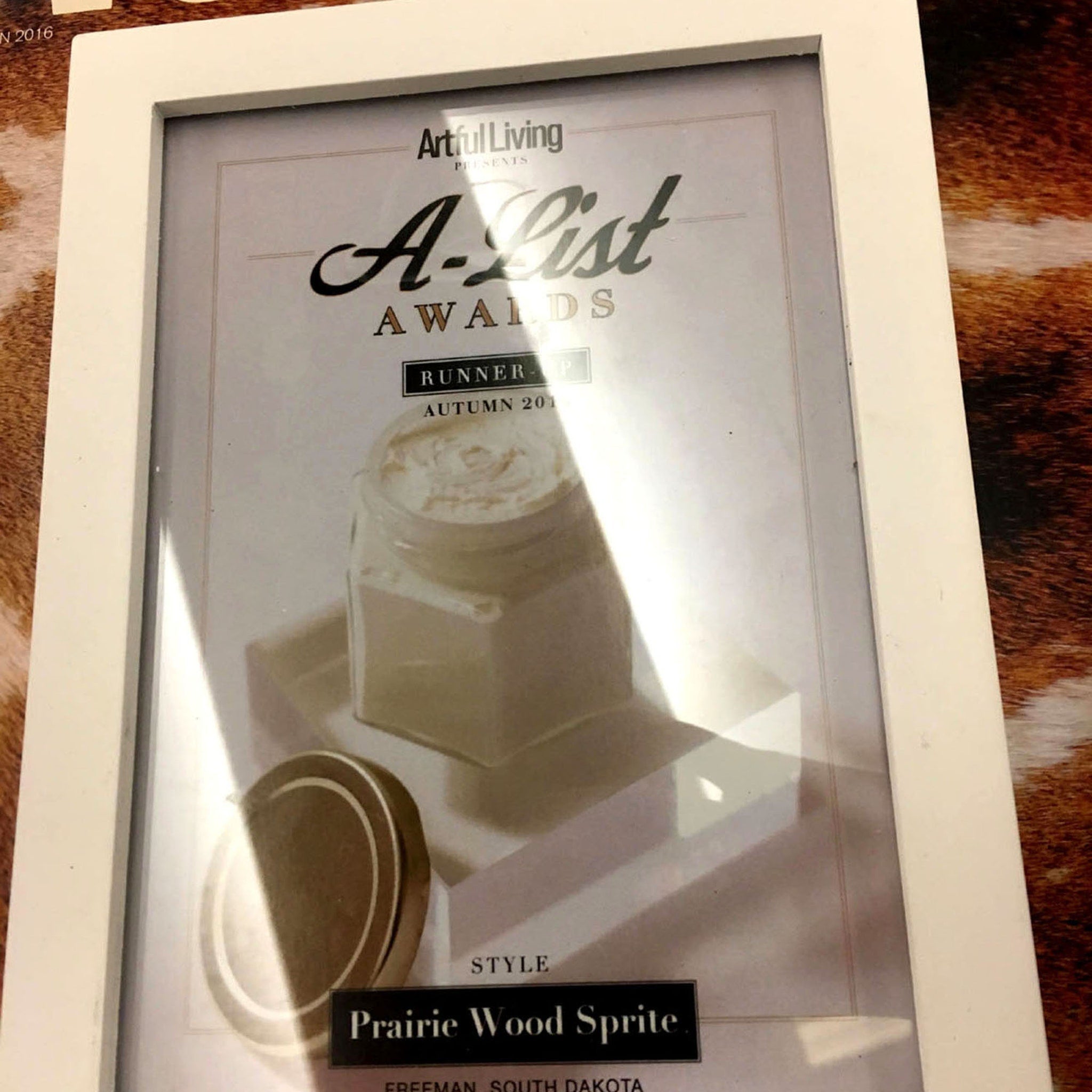 White framed award with "A-List Awards" text, "Prairie Wood Sprite" style, and brown background