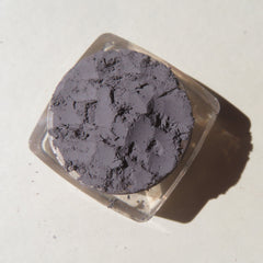 Powder eyeshadow, dark gray powder, clear square container, top-down view
