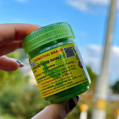 Herb inhaler bottle, green plastic cap, yellow label with text, held in hand