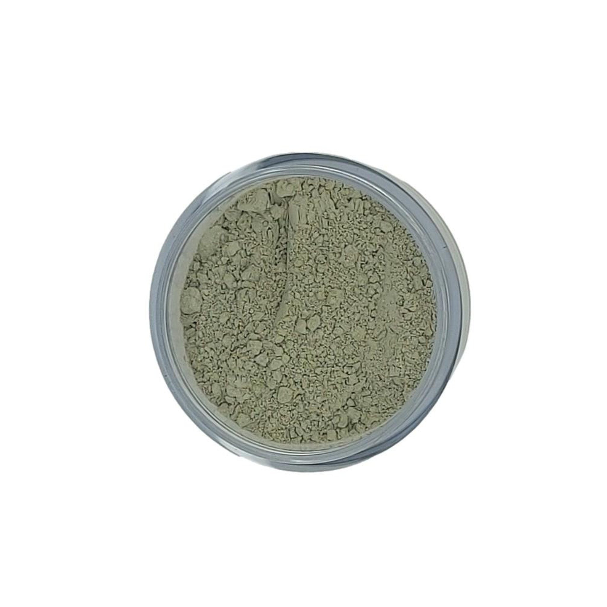 Powdered clay in a clear jar, light green color, grainy texture, top view