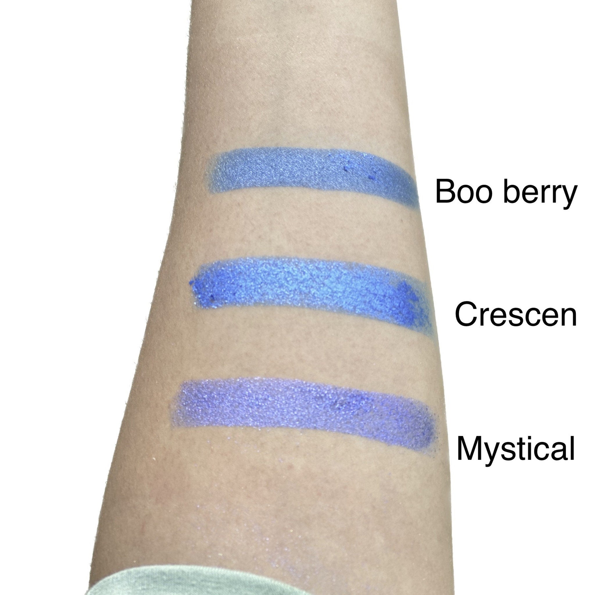 Side view of duo chrome eyeshadow pan showing color shift from bronze to green in minimalist compact