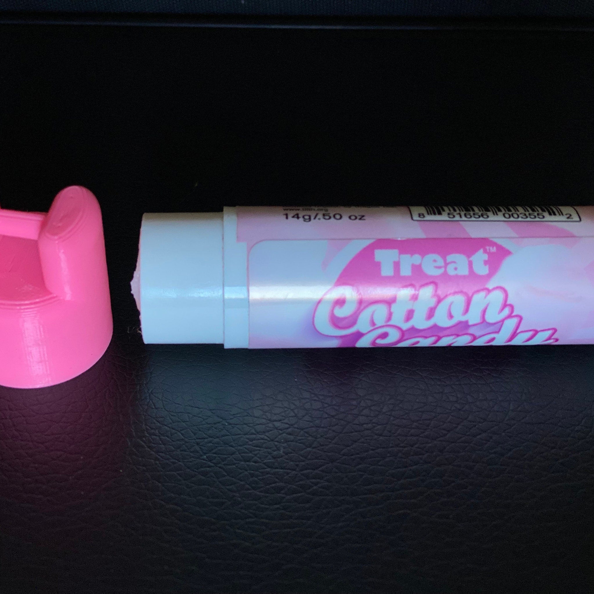 Lip balm tube with pink and white colors, and "Treat Cotton Candy" text visible on the label.