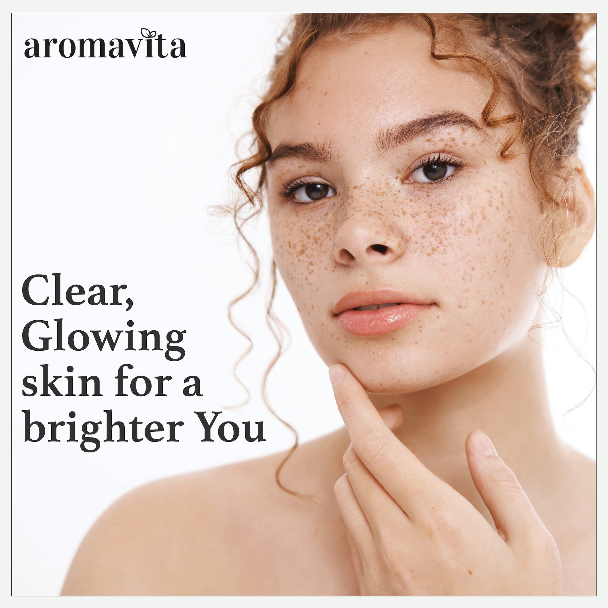 Woman with freckled skin, curly auburn hair, and finger touching chin, aromavita logo visible