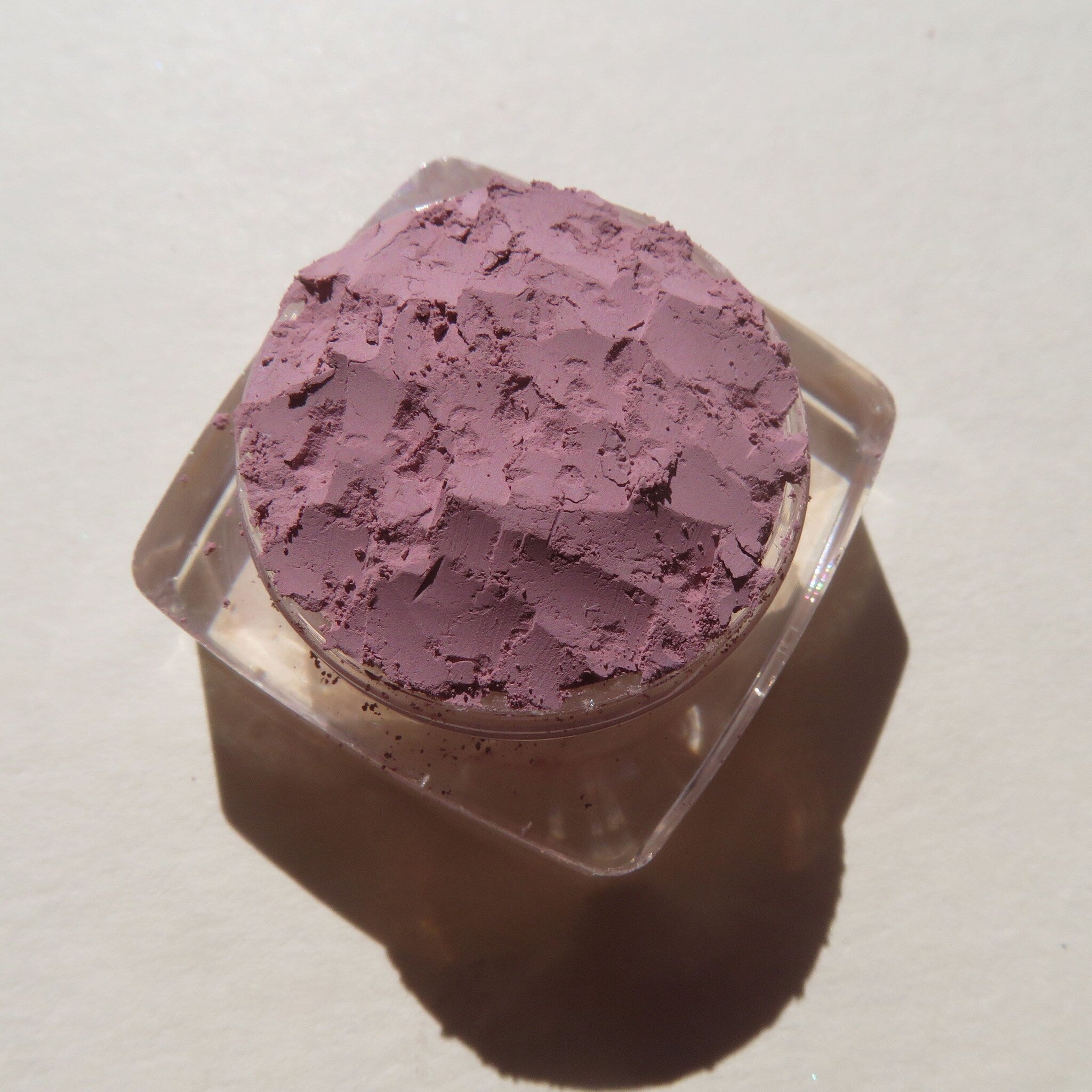 Side view of matte light purple loose mineral eye shadow in Persian Lily shade, showcasing fine powder texture