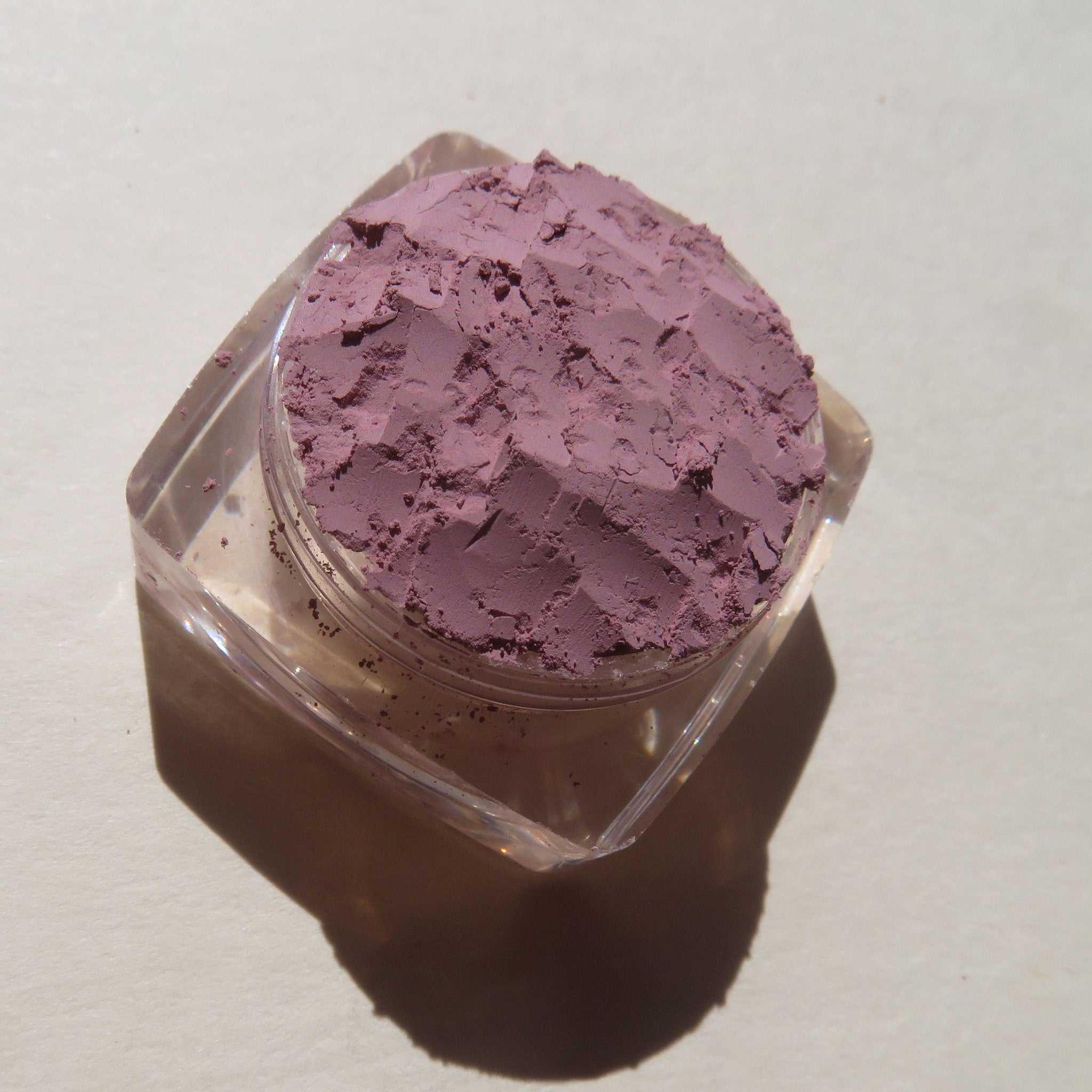 Side view of matte light purple loose mineral eye shadow in Persian Lily shade, showcasing fine mica powder texture
