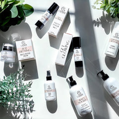 Skincare products in white bottles and boxes with black caps, Caprine brand visible, on white surface
