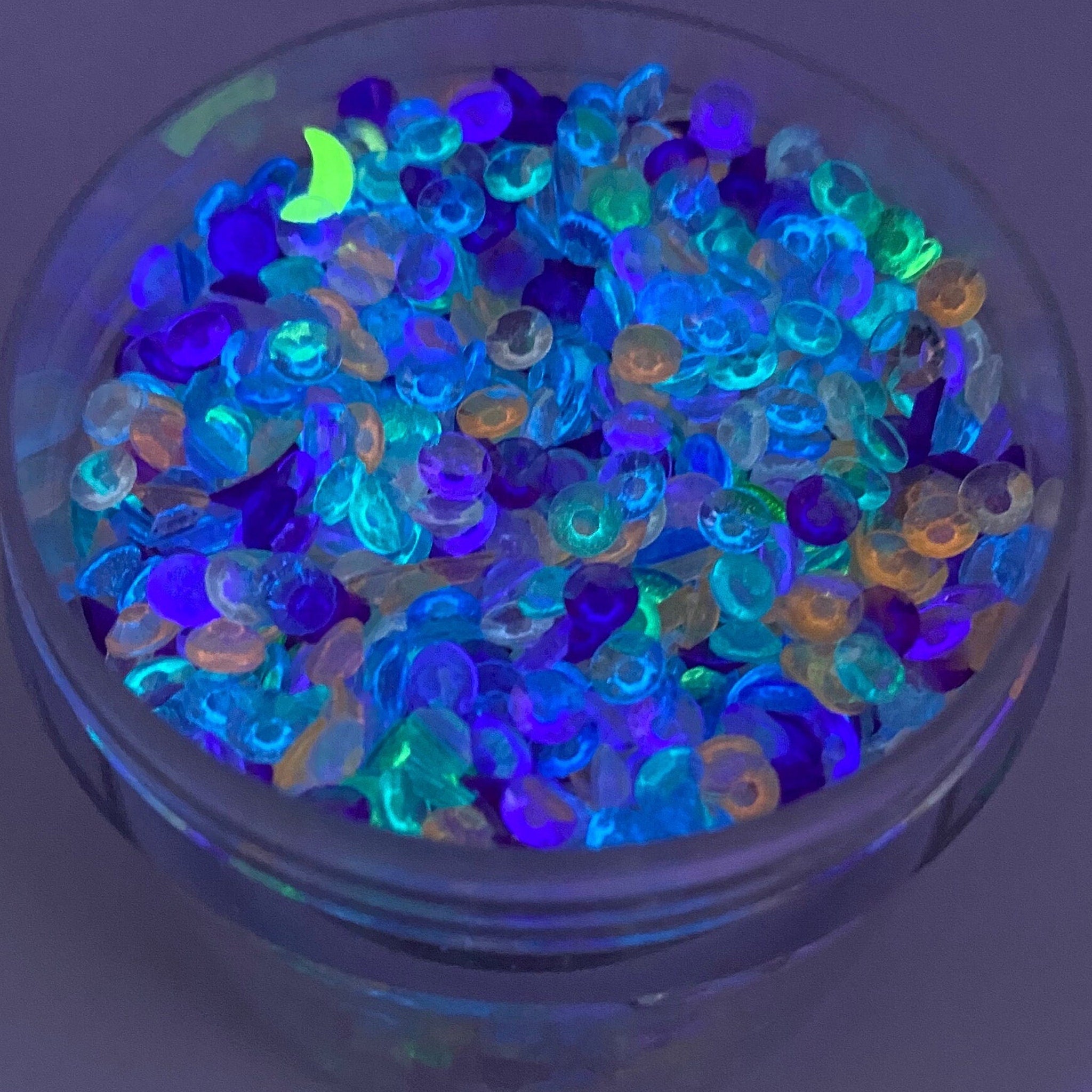 Face gems in a jar, multi-colored iridescent round gems with a neon green moon shape