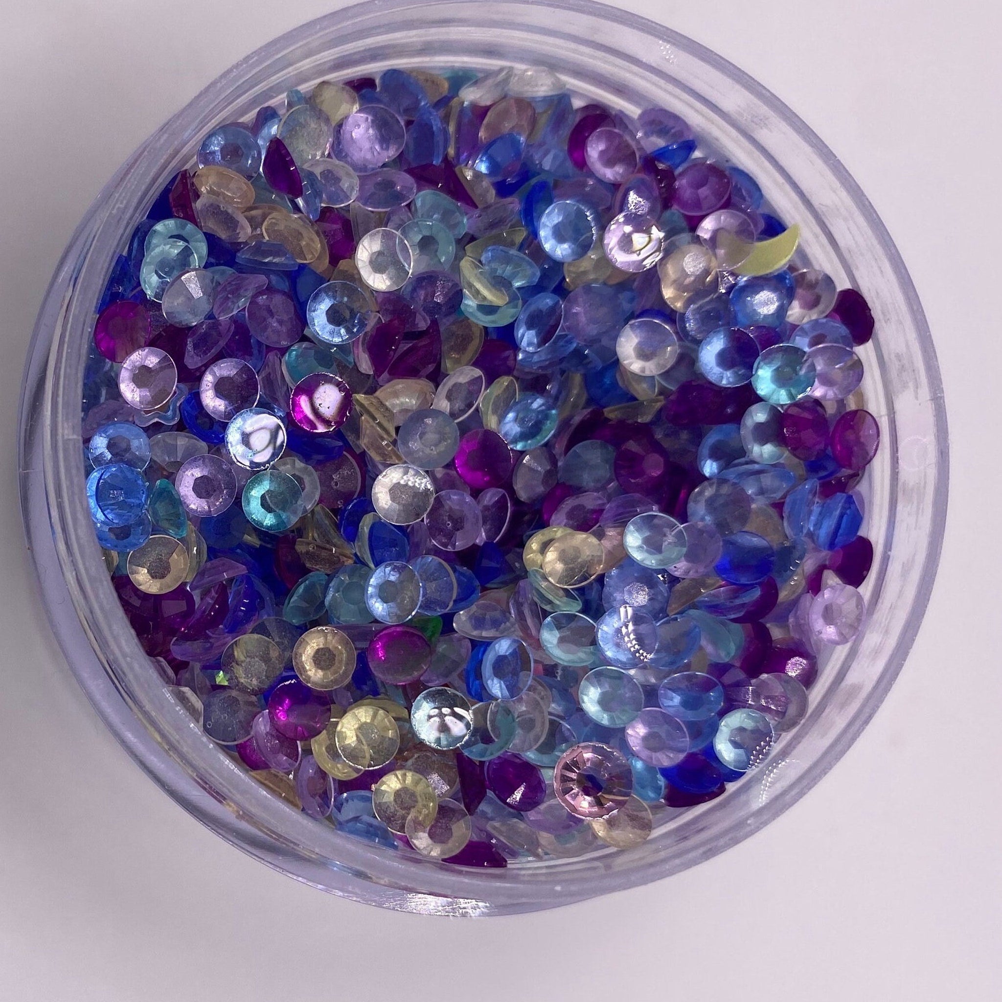 Rhinestones, assorted colors, faceted, in a clear plastic container
