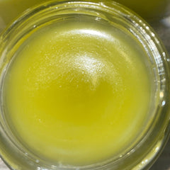 Yellow liquid in a clear glass jar, with a smooth texture and reflective surface