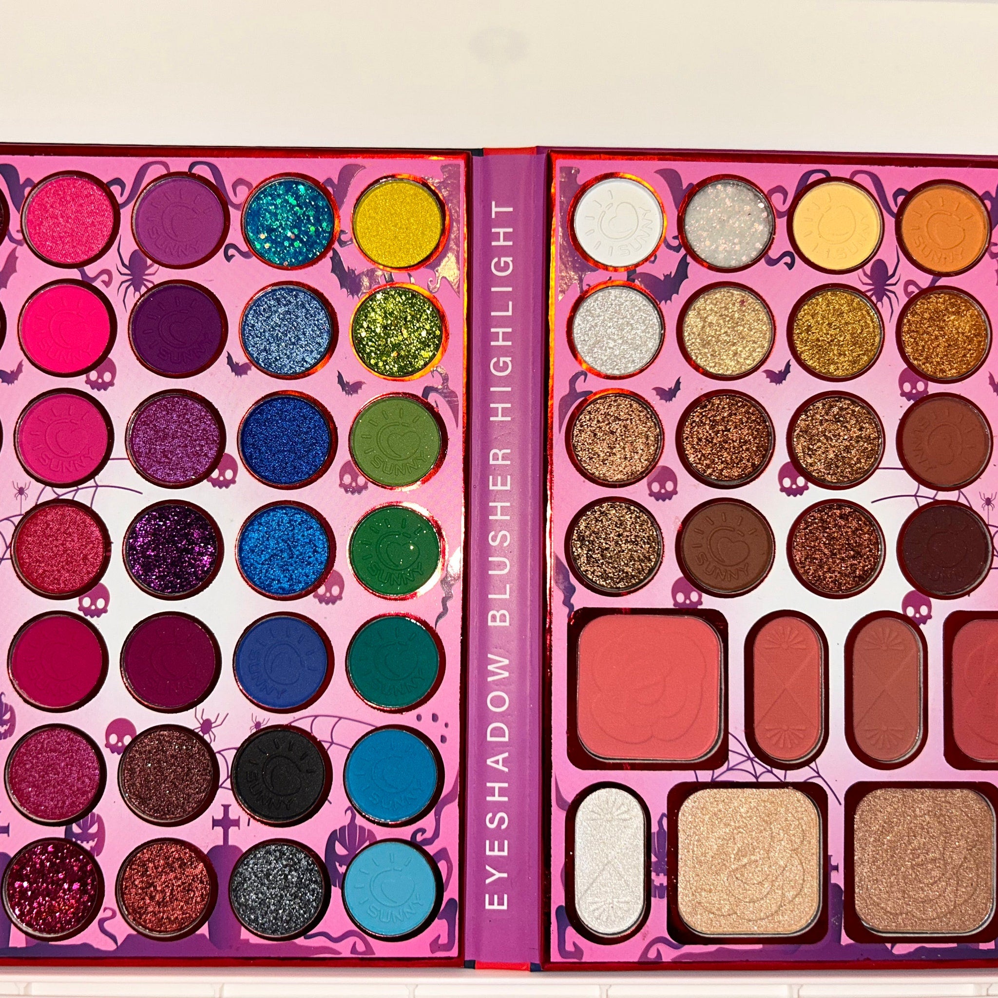 Side view of Halloween eye shadow palette showing vibrant matte and shimmer shades in orange, black, and purple