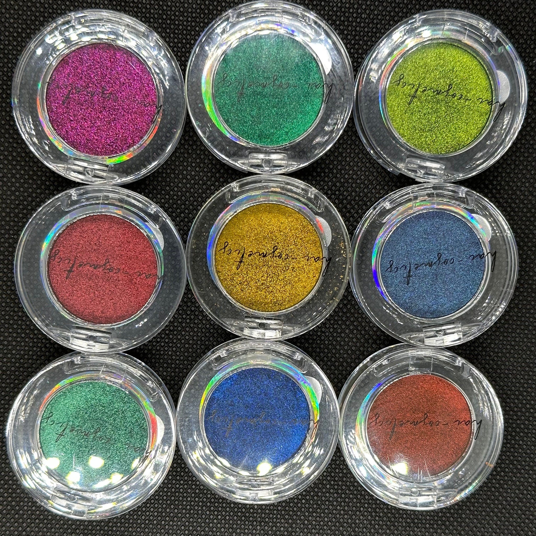 Hand applying shimmering duo chrome eye shadow with fingertip, showcasing metallic color shift on eyelid